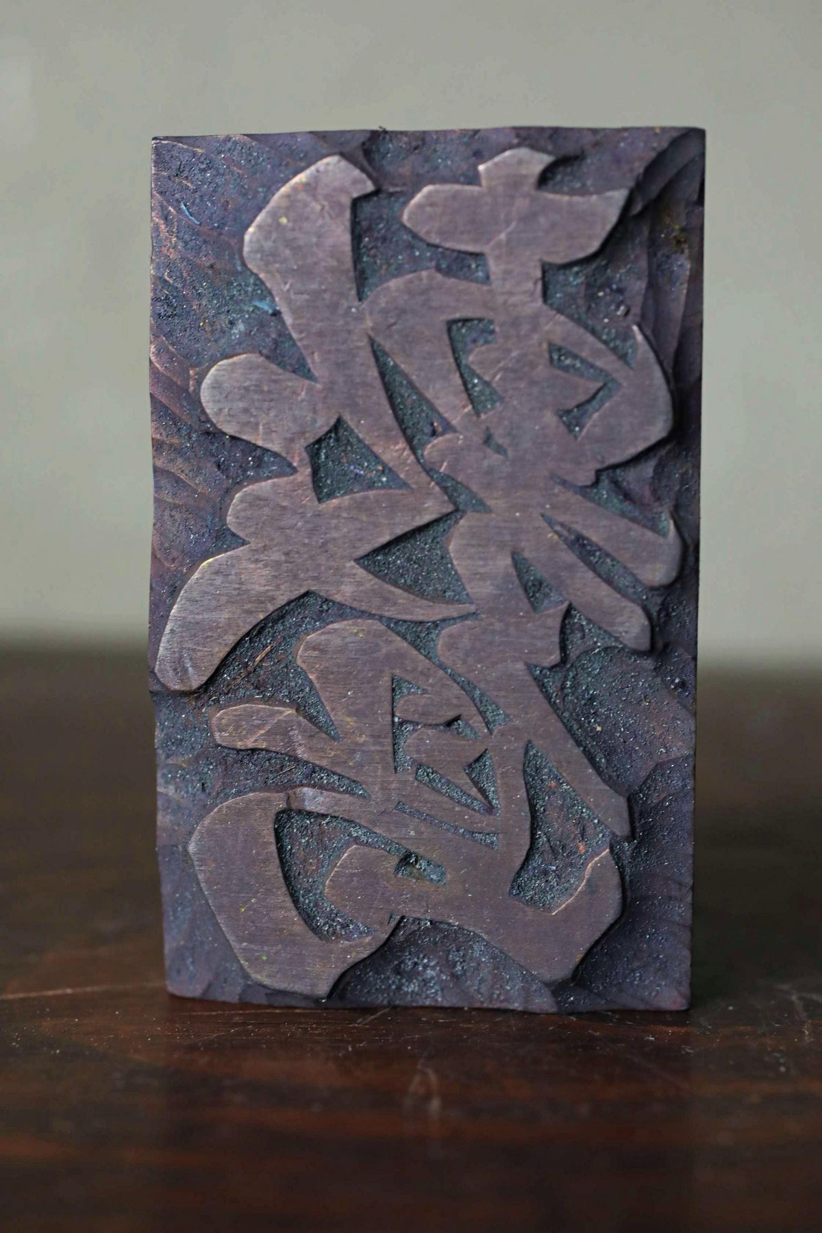 a dark-colored rectangular object with an intricate, abstract design carved into it.