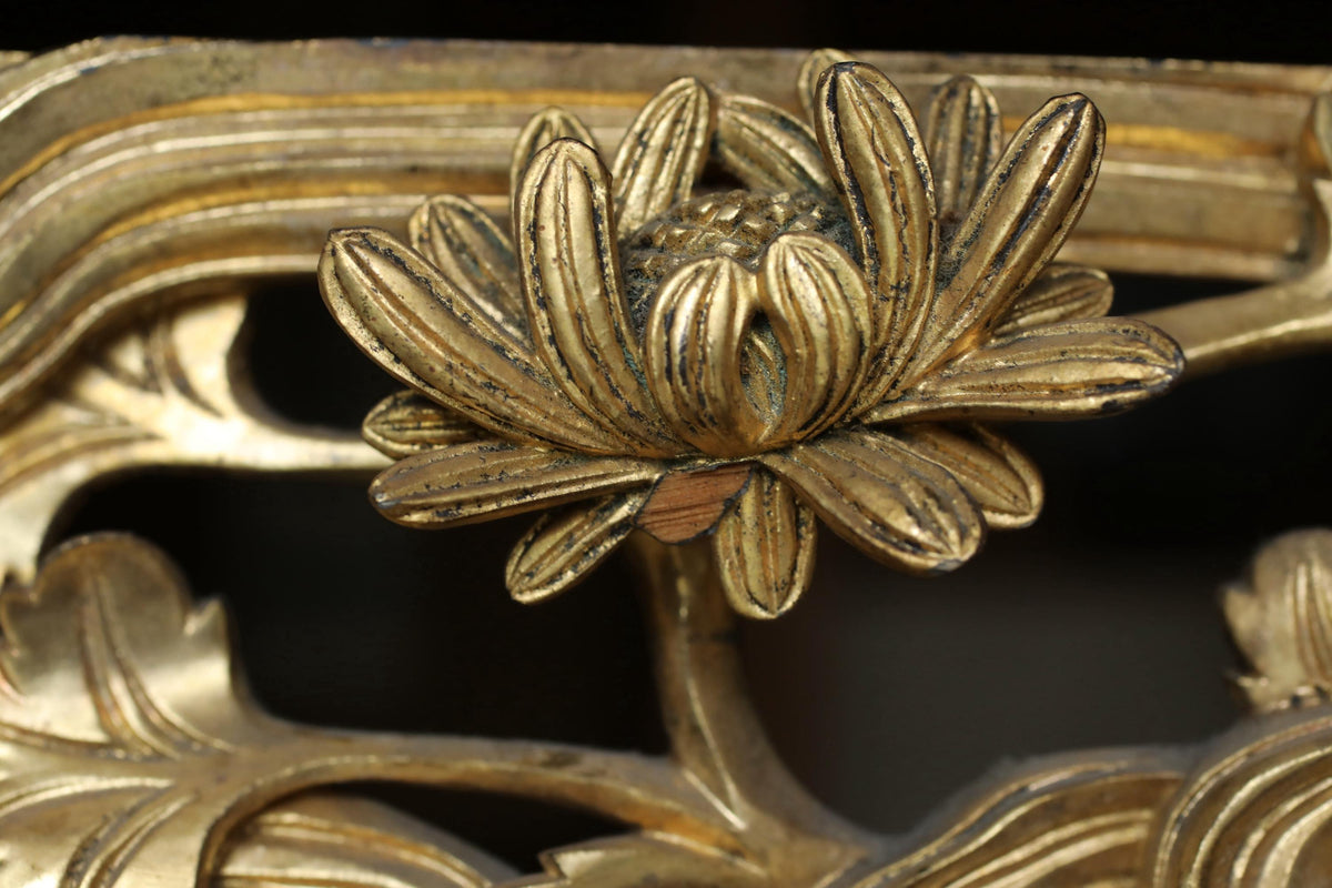 A close-up view of a decorative golden flower-like object, possibly a piece of art or a sculpture, with intricate details and patterns.