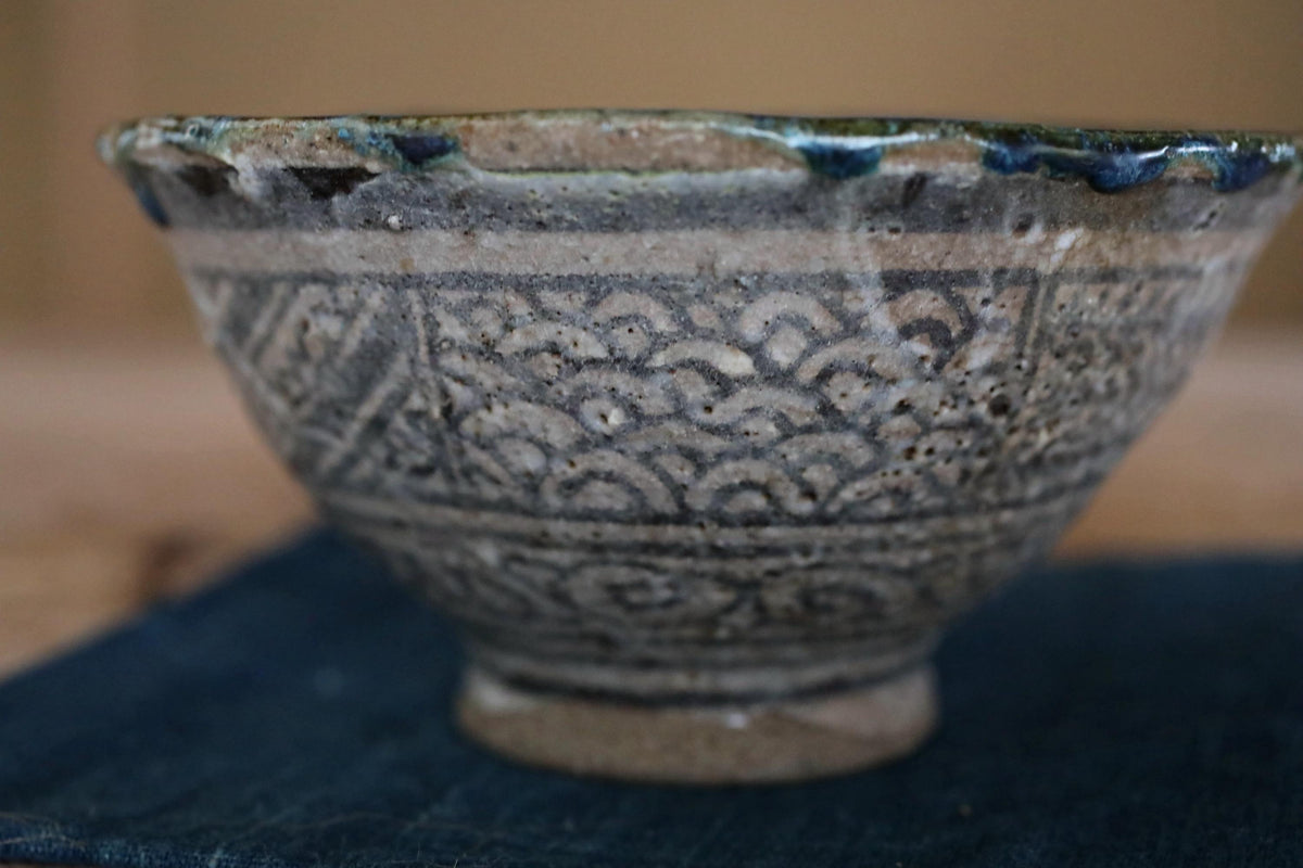 A close-up image of a ceramic bowl with a decorative pattern on its surface.