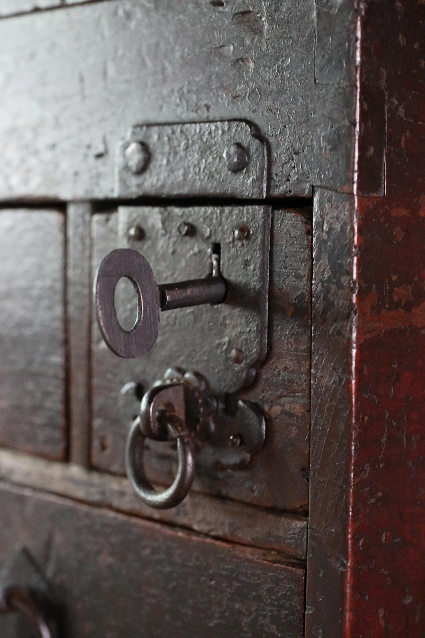 a close-up view of a metal lock with a keyhole and a metal latch, set into a wooden surface.