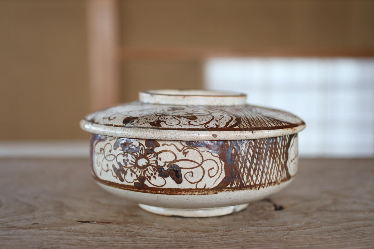 A white ceramic bowl with a decorative pattern on its surface, placed on a wooden surface.