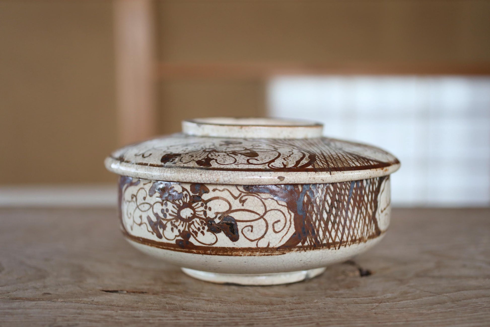 A white ceramic bowl with a decorative pattern on its surface, placed on a wooden surface.