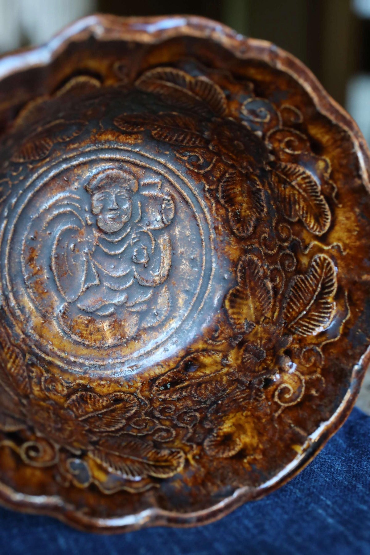 a close-up view of a brown, intricately decorated bowl with a floral pattern.