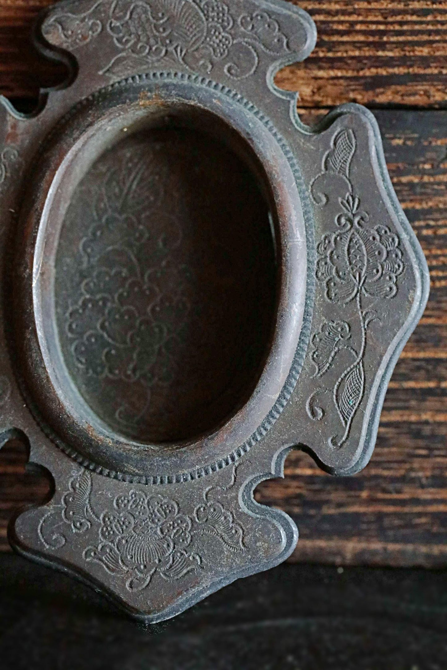 a close-up view of an ornate, antique-looking metal object with a floral design on its surface.