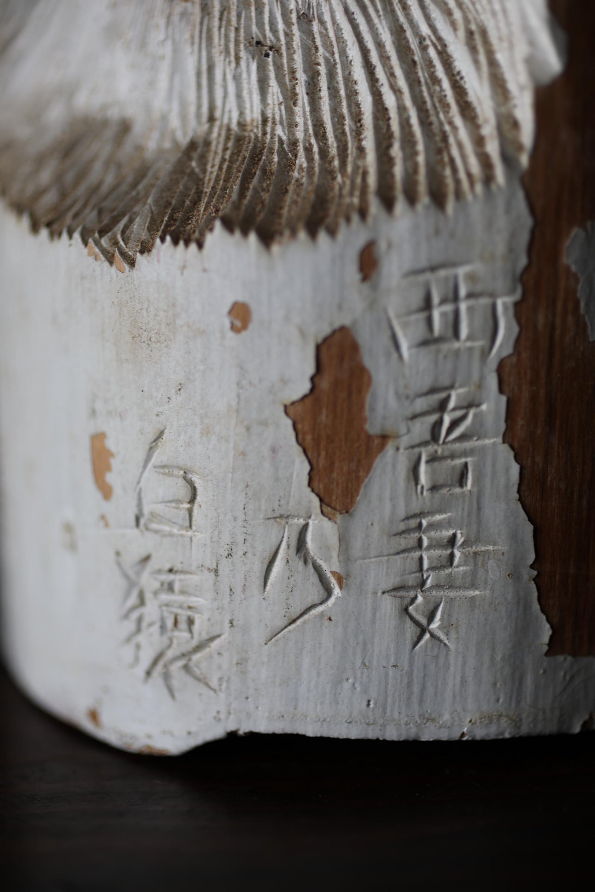 a close-up view of a white, textured surface with some Asian characters carved into it.