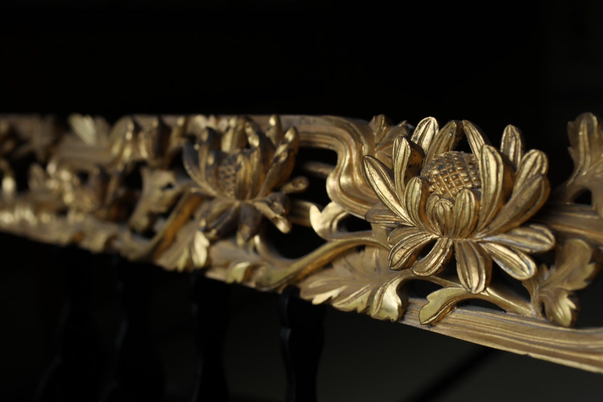 a close-up view of a decorative gold-colored metal railing with intricate floral designs.