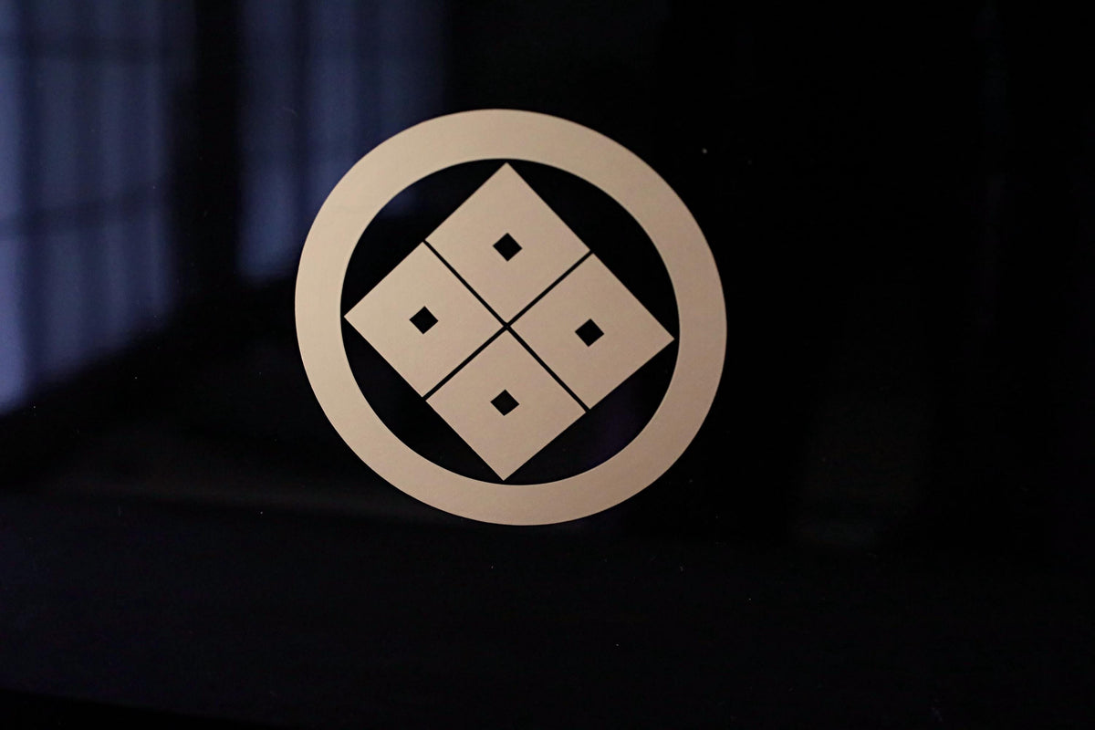 a circular symbol with four squares arranged in a square grid pattern.