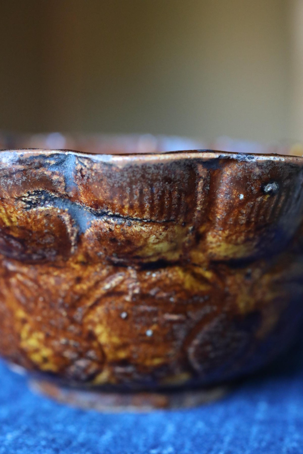 A close-up image of a brown, textured ceramic bowl with a patterned design.