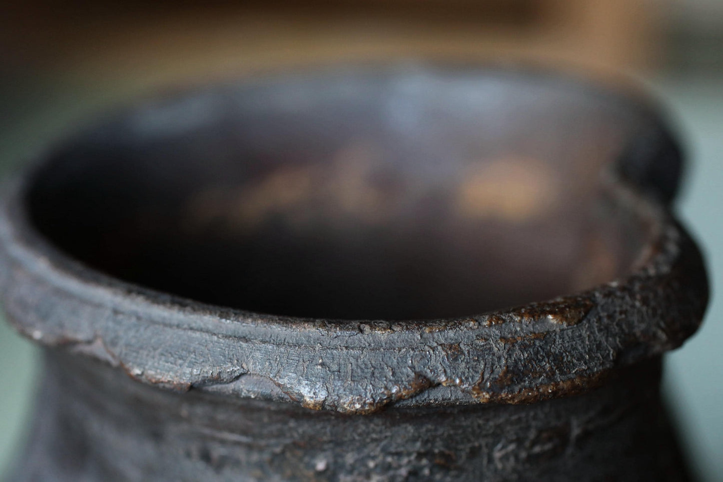 A close-up view of a rusted, black metal object with a textured surface.