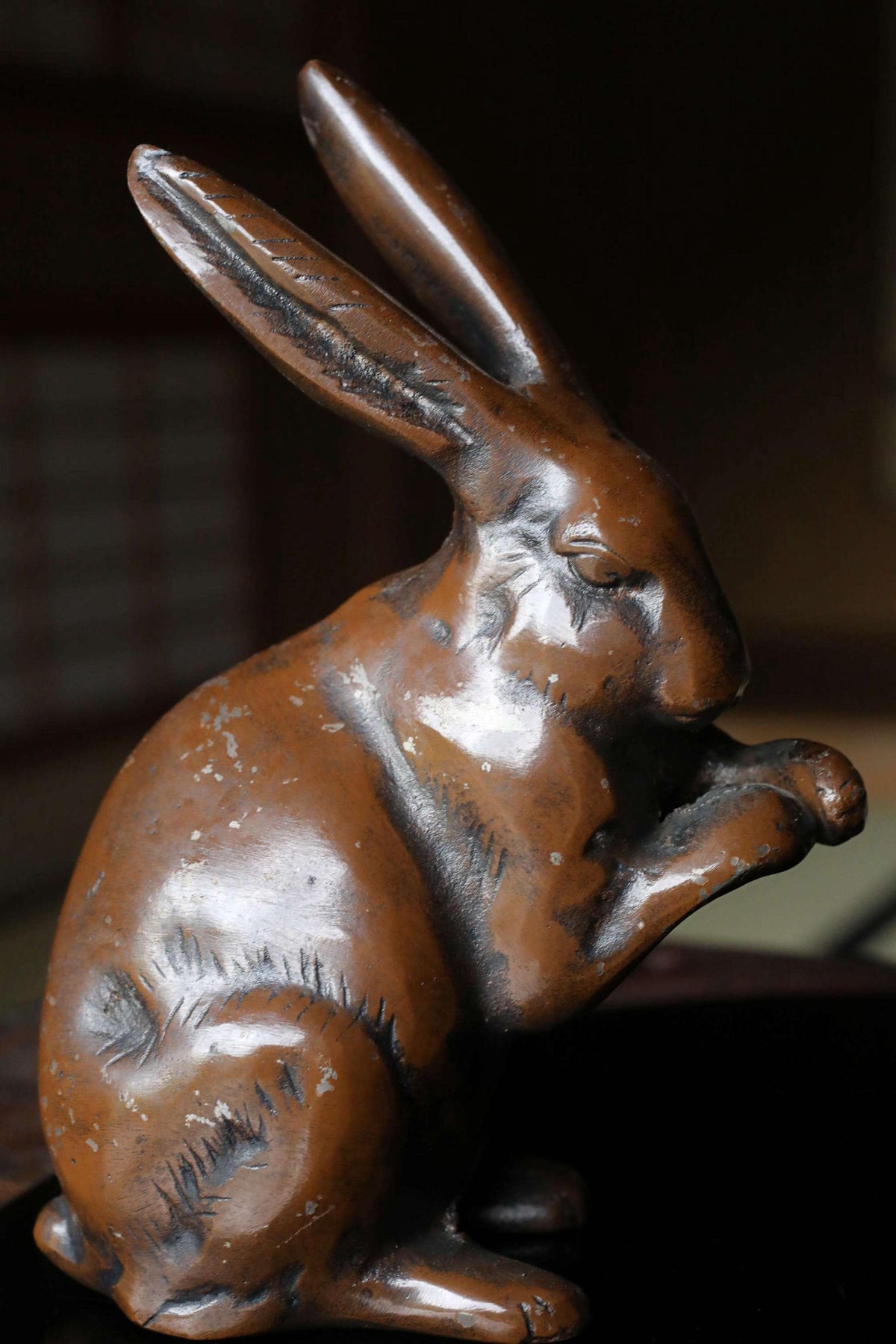 A bronze statue of a rabbit sitting on its hind legs.