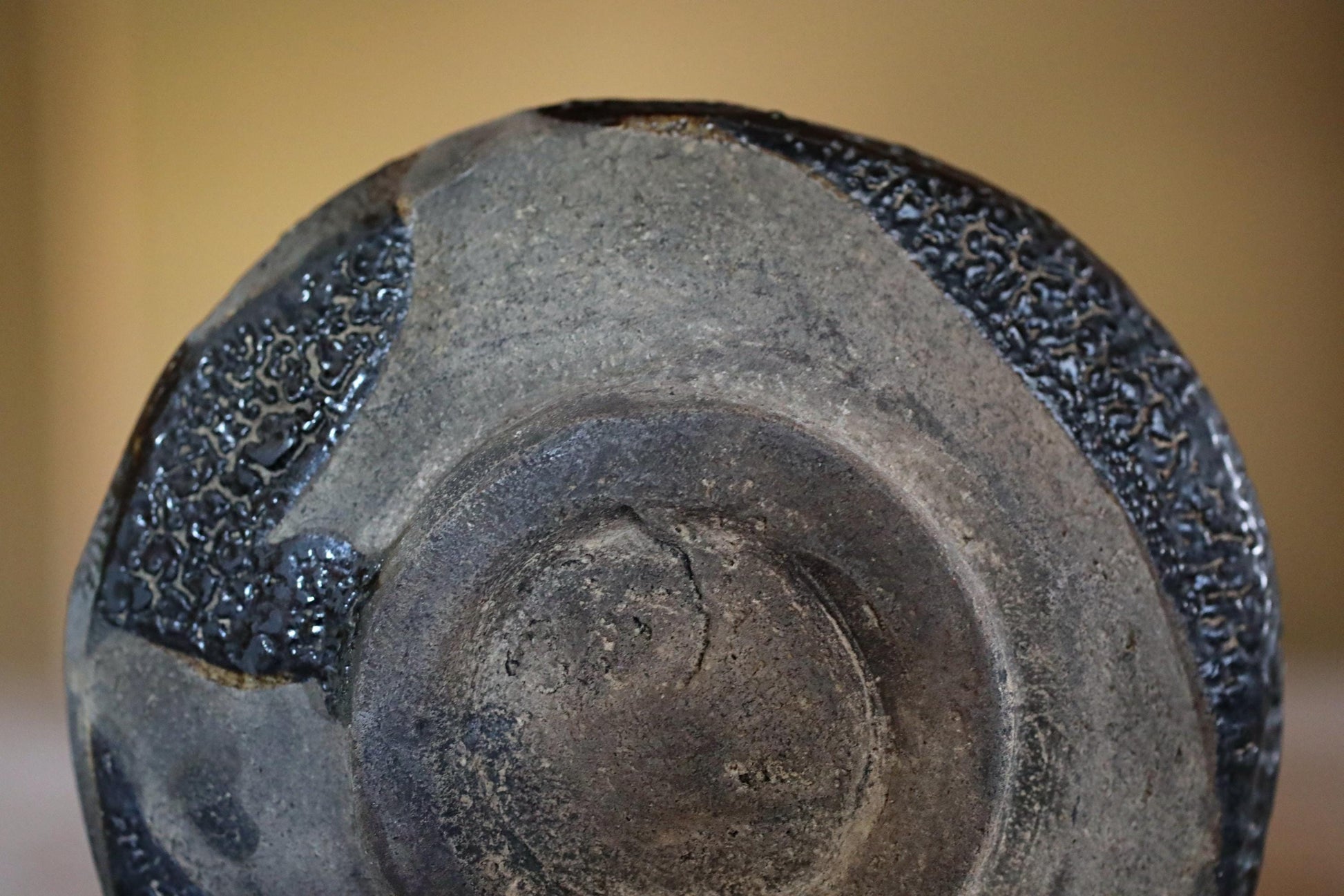 a close-up view of a black, textured ceramic object with a dark, glossy finish.