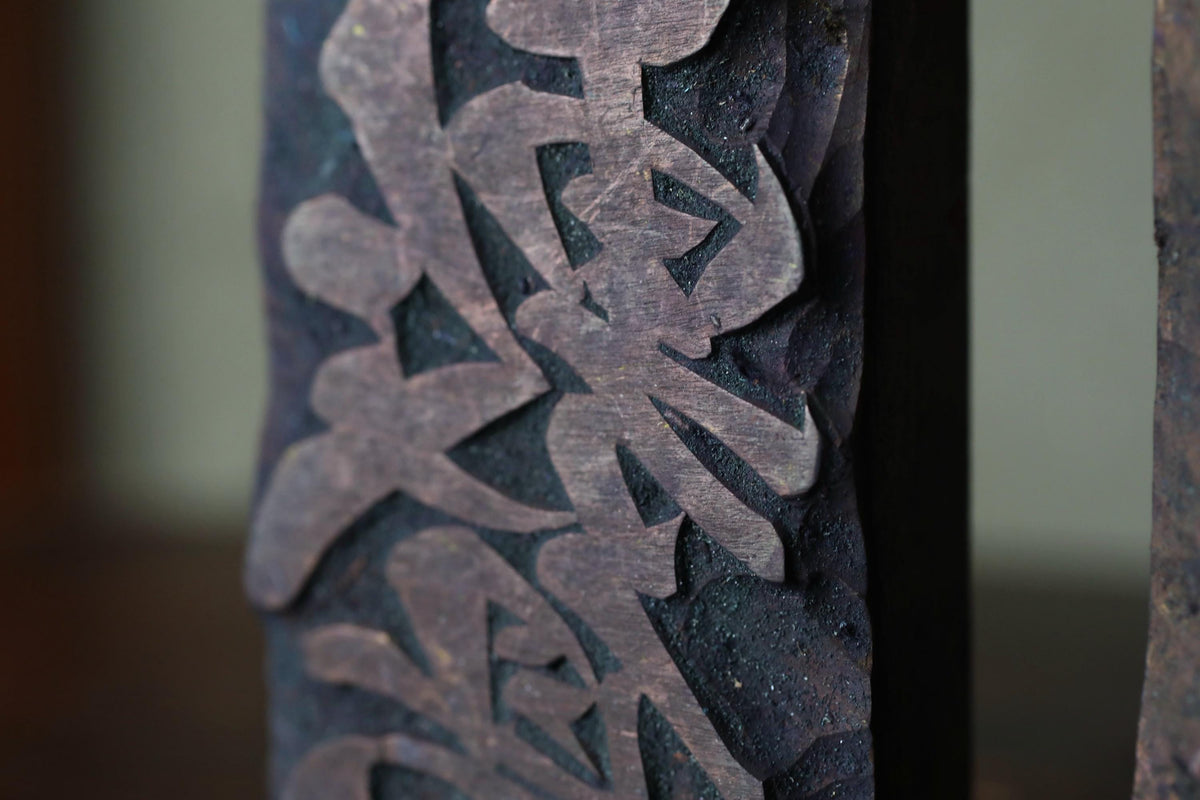 a close-up view of a dark wooden surface with intricate carved patterns or designs, including what appears to be Chinese characters or text.