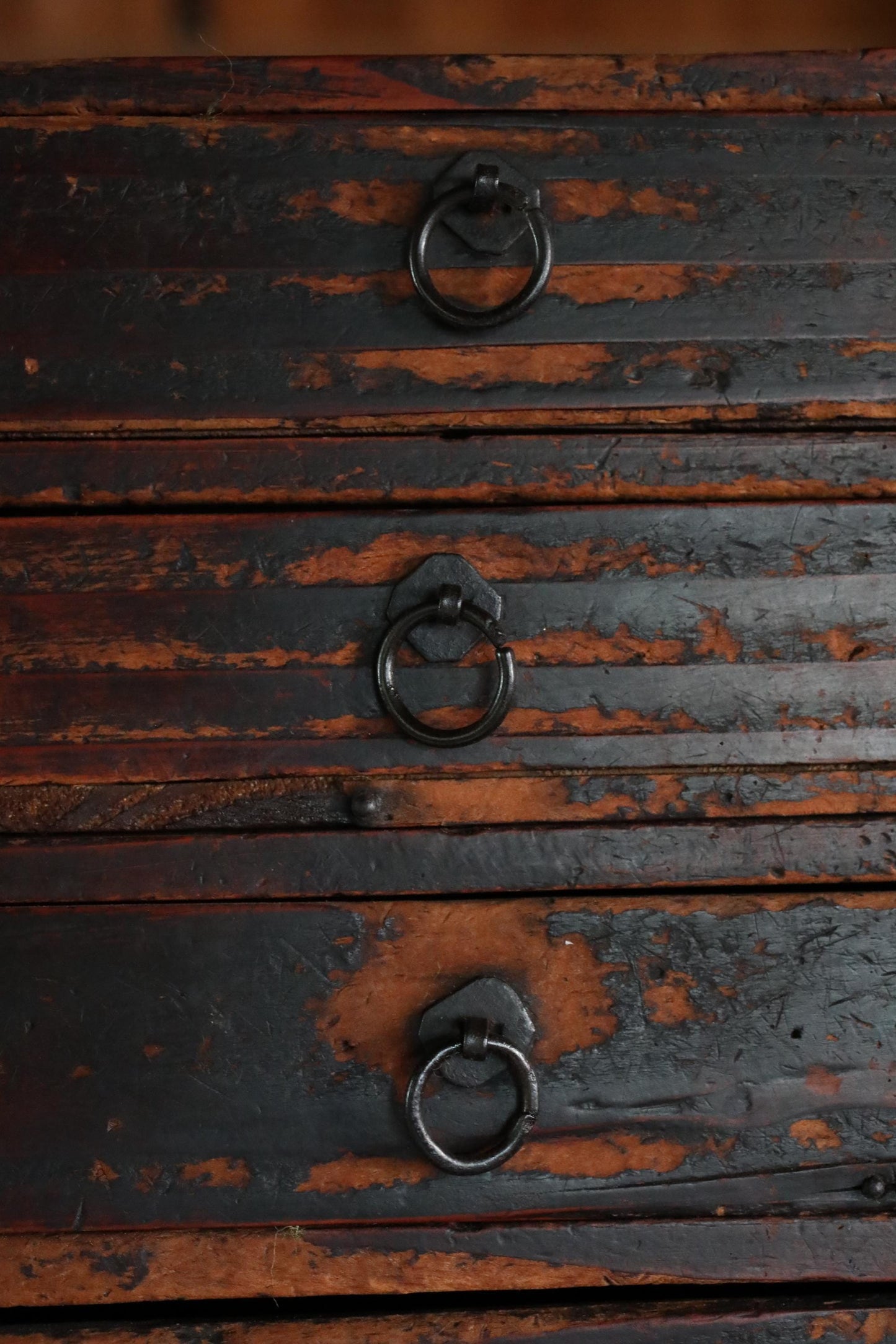 a close-up view of a wooden drawer with three metal handles, all of which appear to be in good condition.