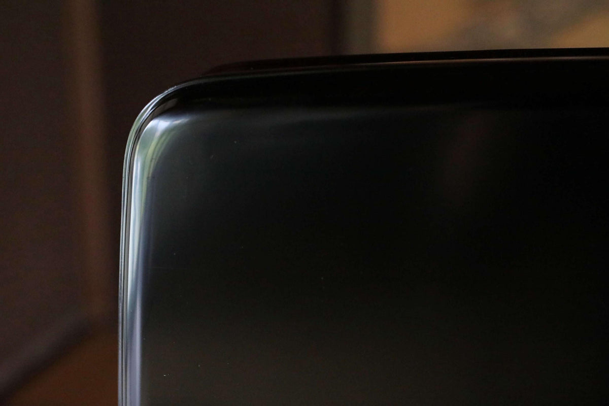 The image is a close-up of a black surface, possibly a piece of furniture or a wall, with a blurred background.