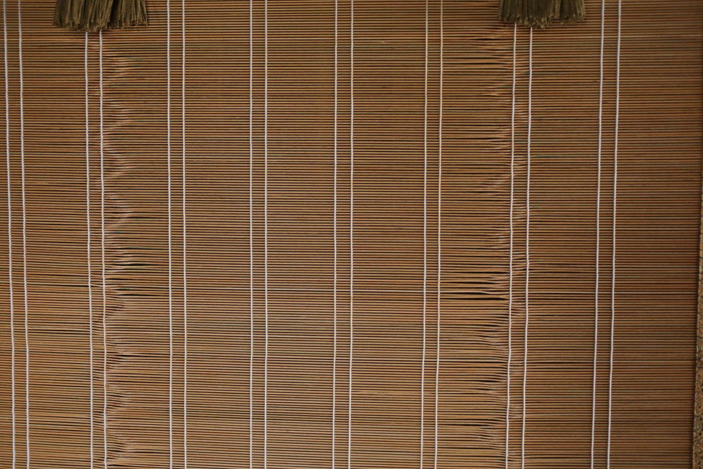 a close-up view of a bamboo blind with vertical slats, creating a textured and patterned appearance.