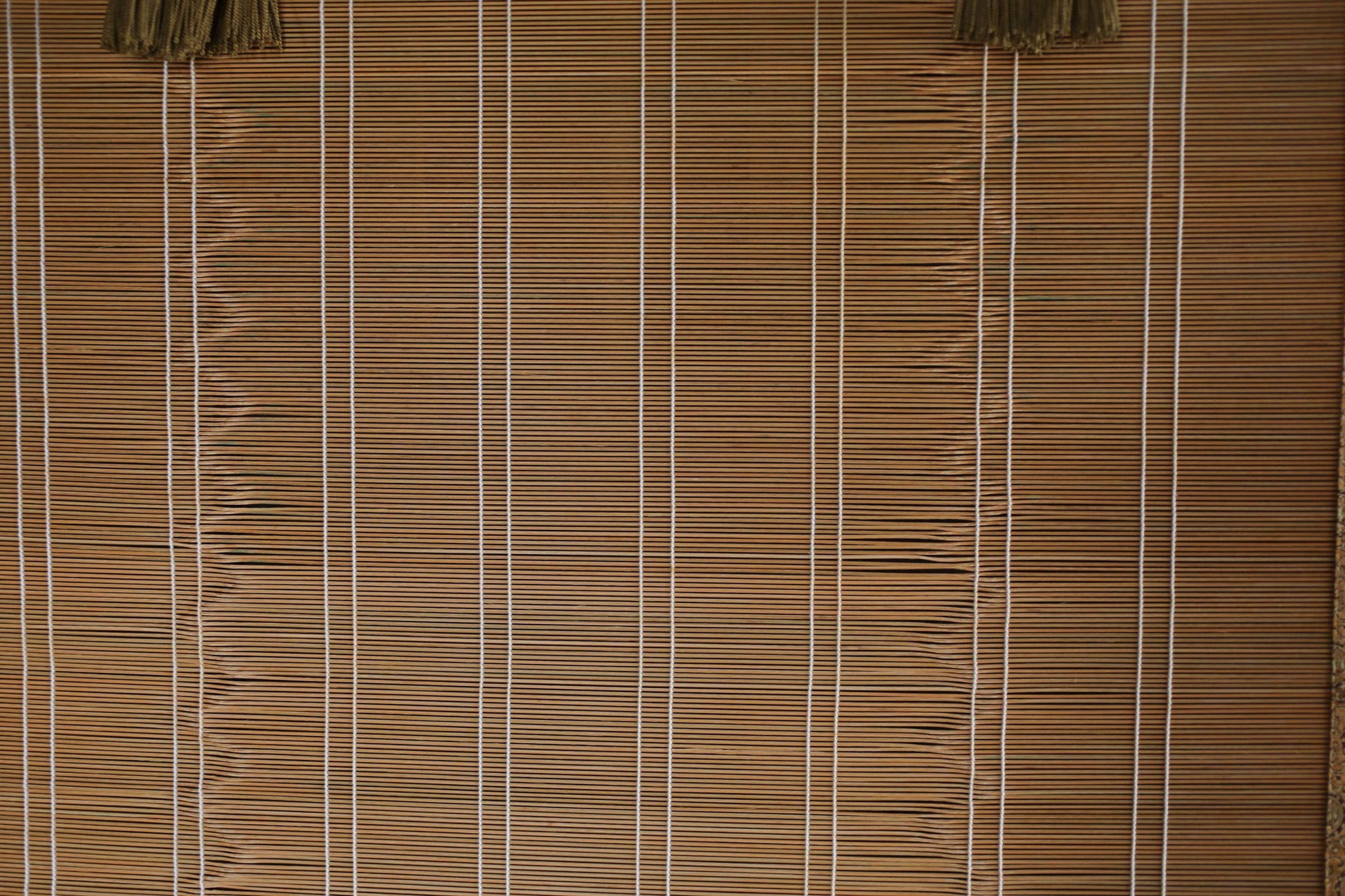 a close-up view of a bamboo blind with vertical slats, creating a textured and patterned appearance.