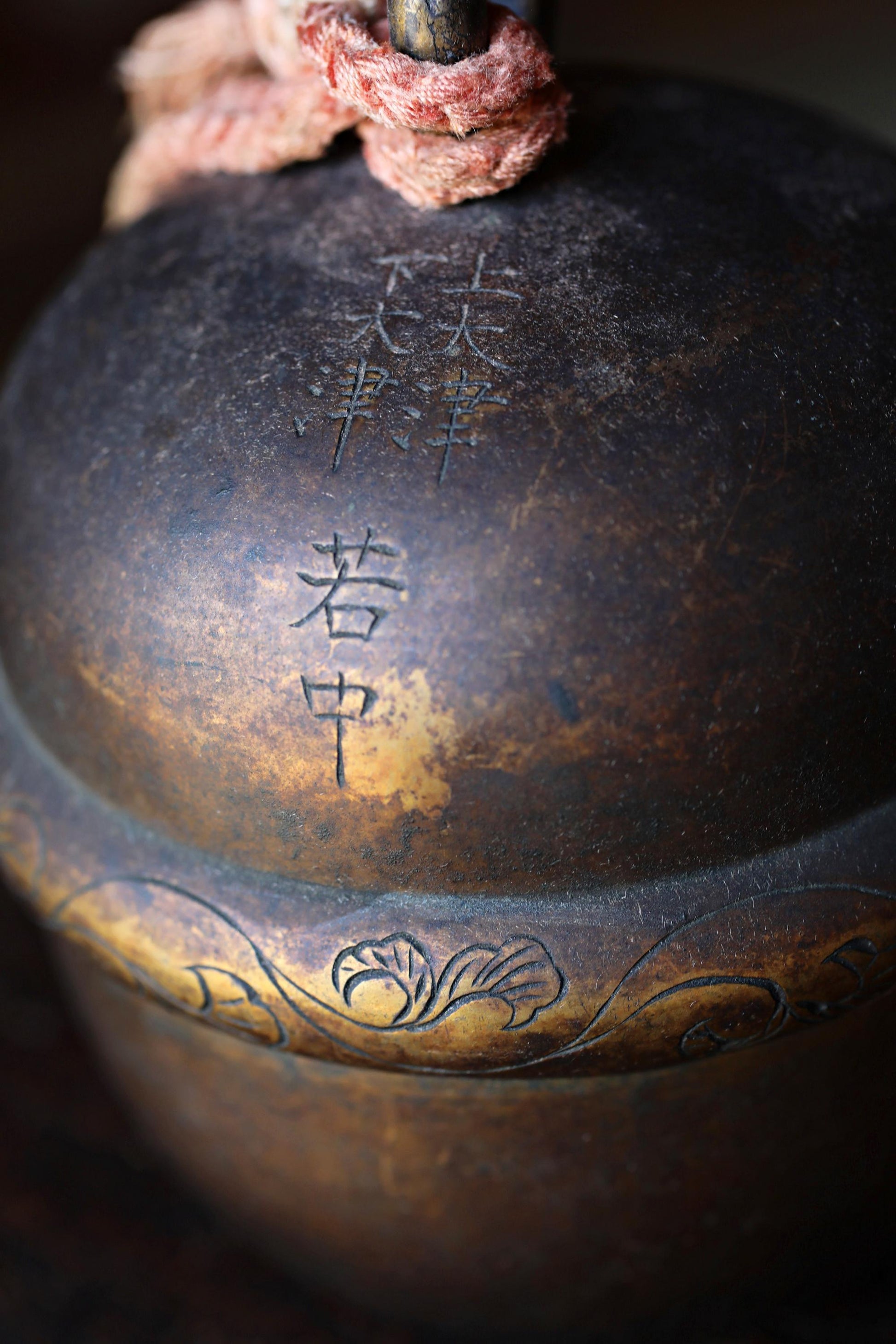 a close-up view of a dark, ornate metal object with Chinese characters and a decorative design.