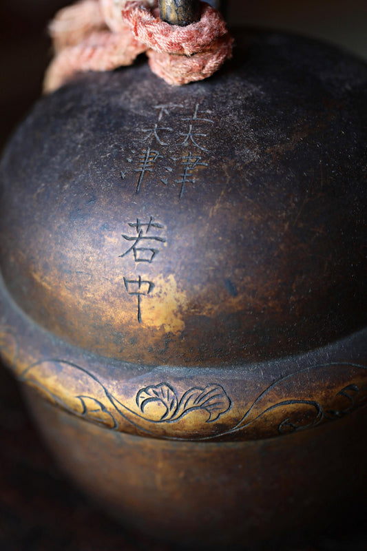 a close-up view of a dark, ornate metal object with Chinese characters and a decorative design.