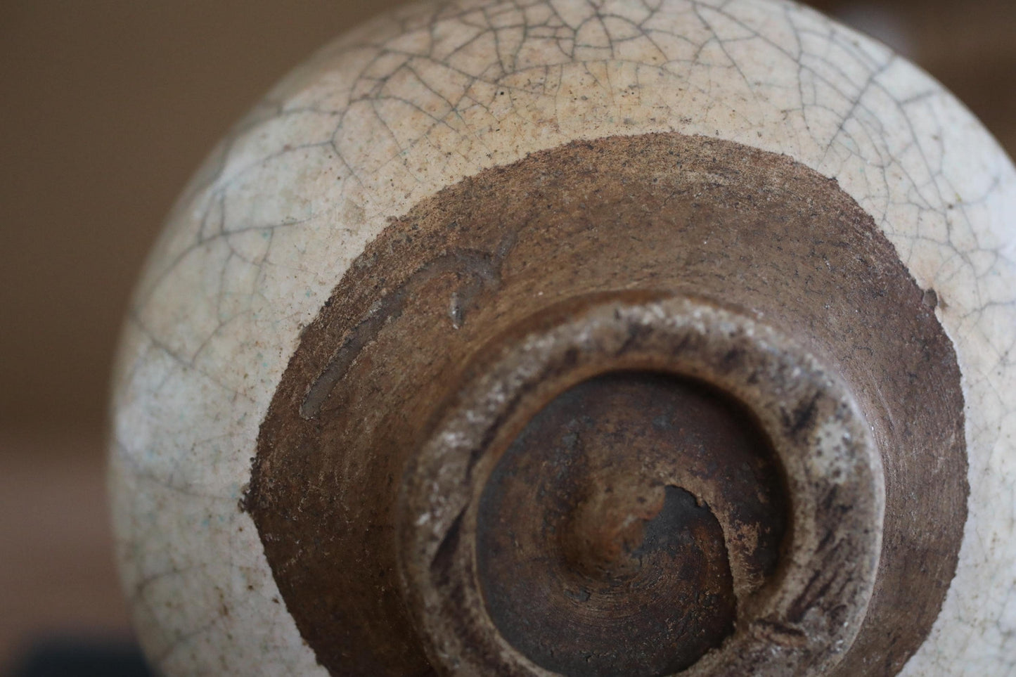 A close-up view of a ceramic vase with a white and brown color scheme, showing the intricate details and textures of the pottery.