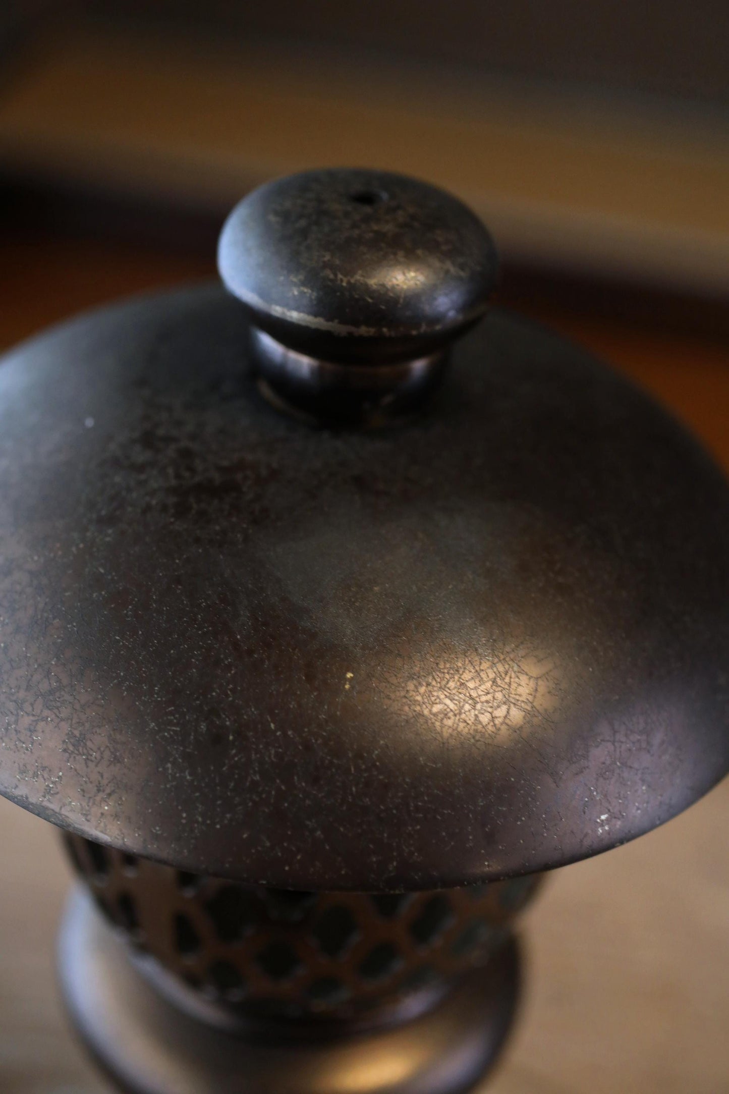 a close-up view of a dark, textured metal object with a round, domed top.