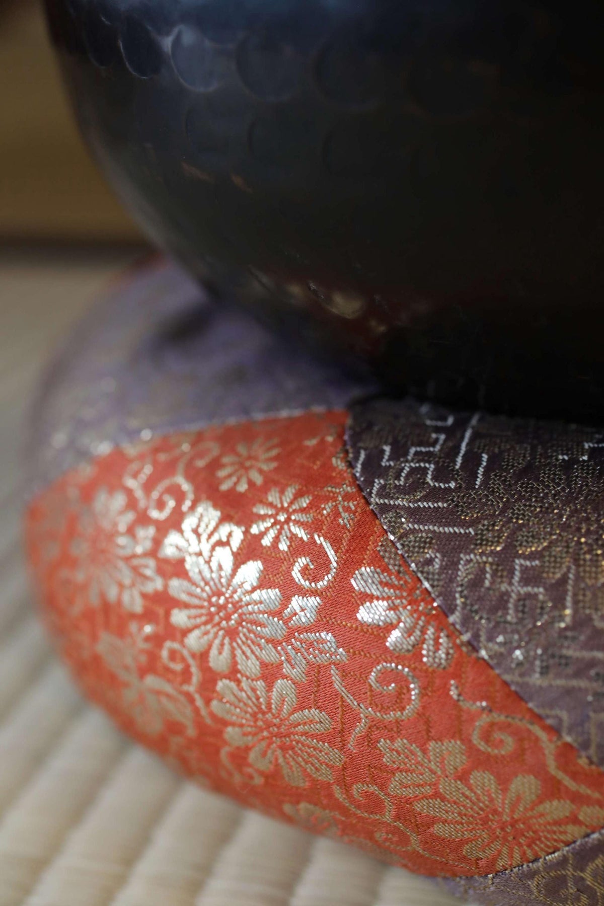 a close-up view of a decorative orange and purple fabric with a floral pattern, resting on a surface.