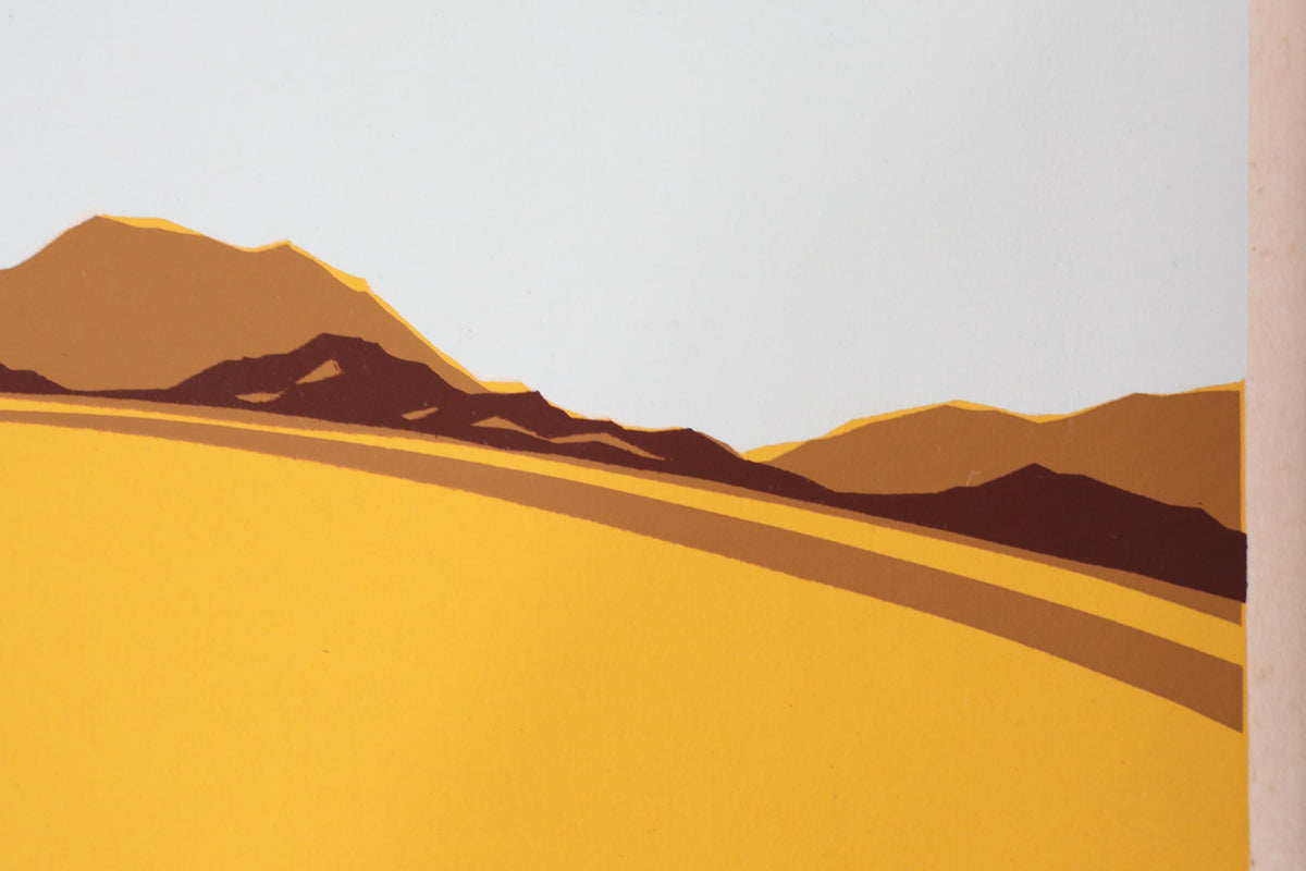 a serene landscape with a yellow field and brown mountains in the background.