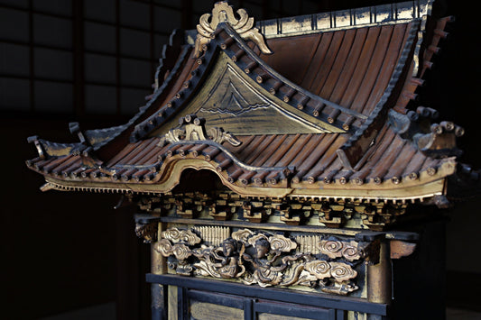 a traditional Japanese temple with intricate carvings and decorations, including a pointed roof and ornate details.