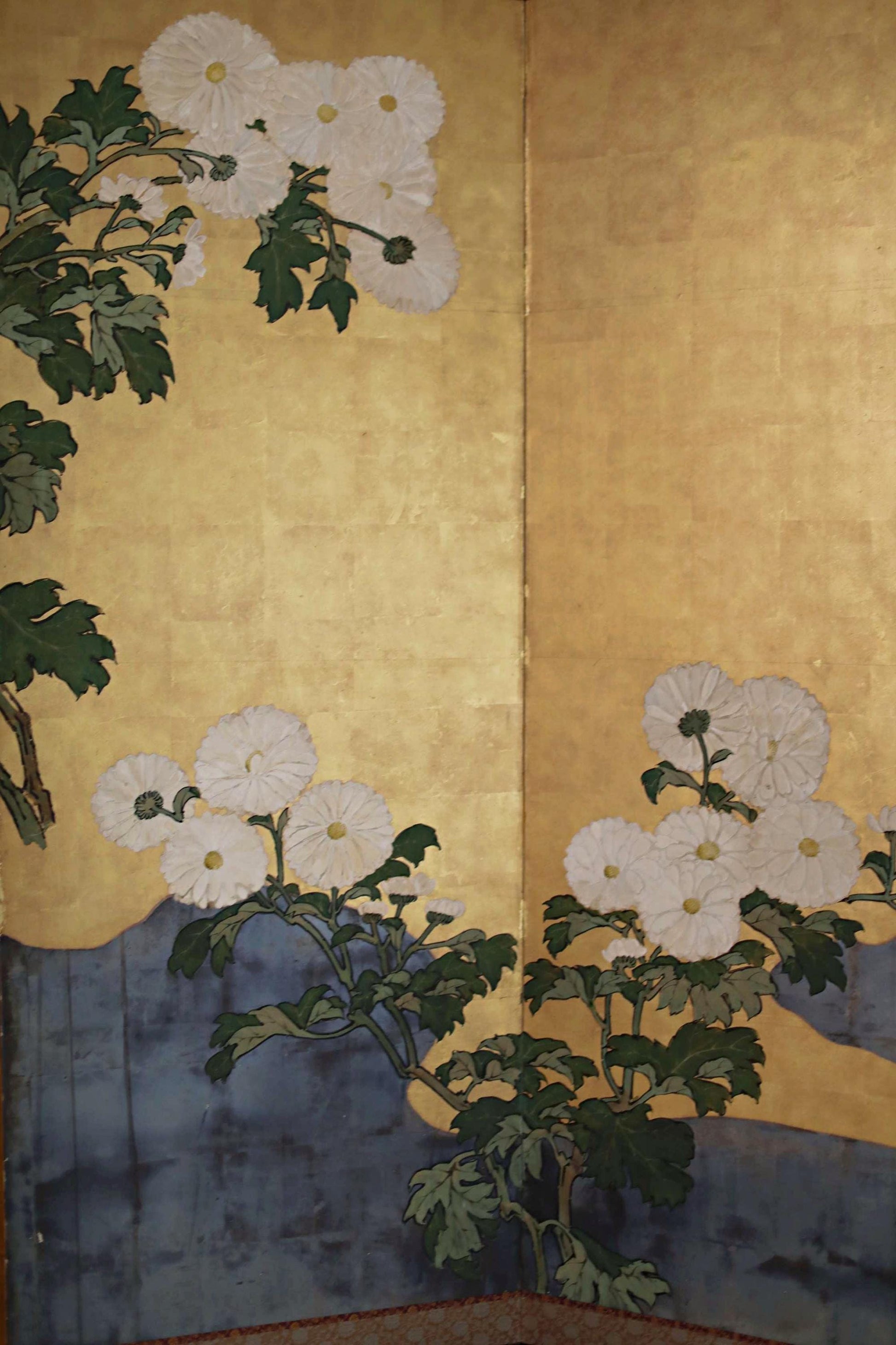 The image is a large, colorful painting featuring white flowers and green leaves against a golden background.