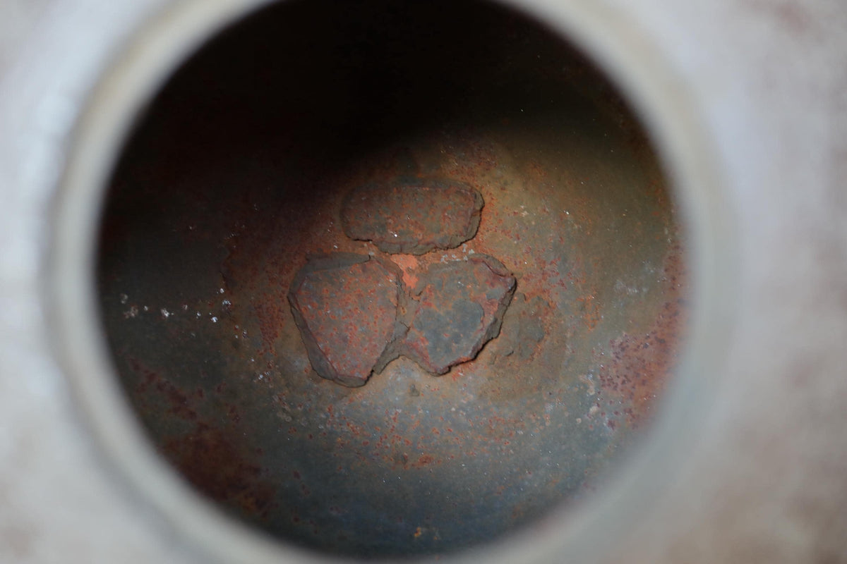 a close-up view of a rusted metal surface with a circular hole in the center.