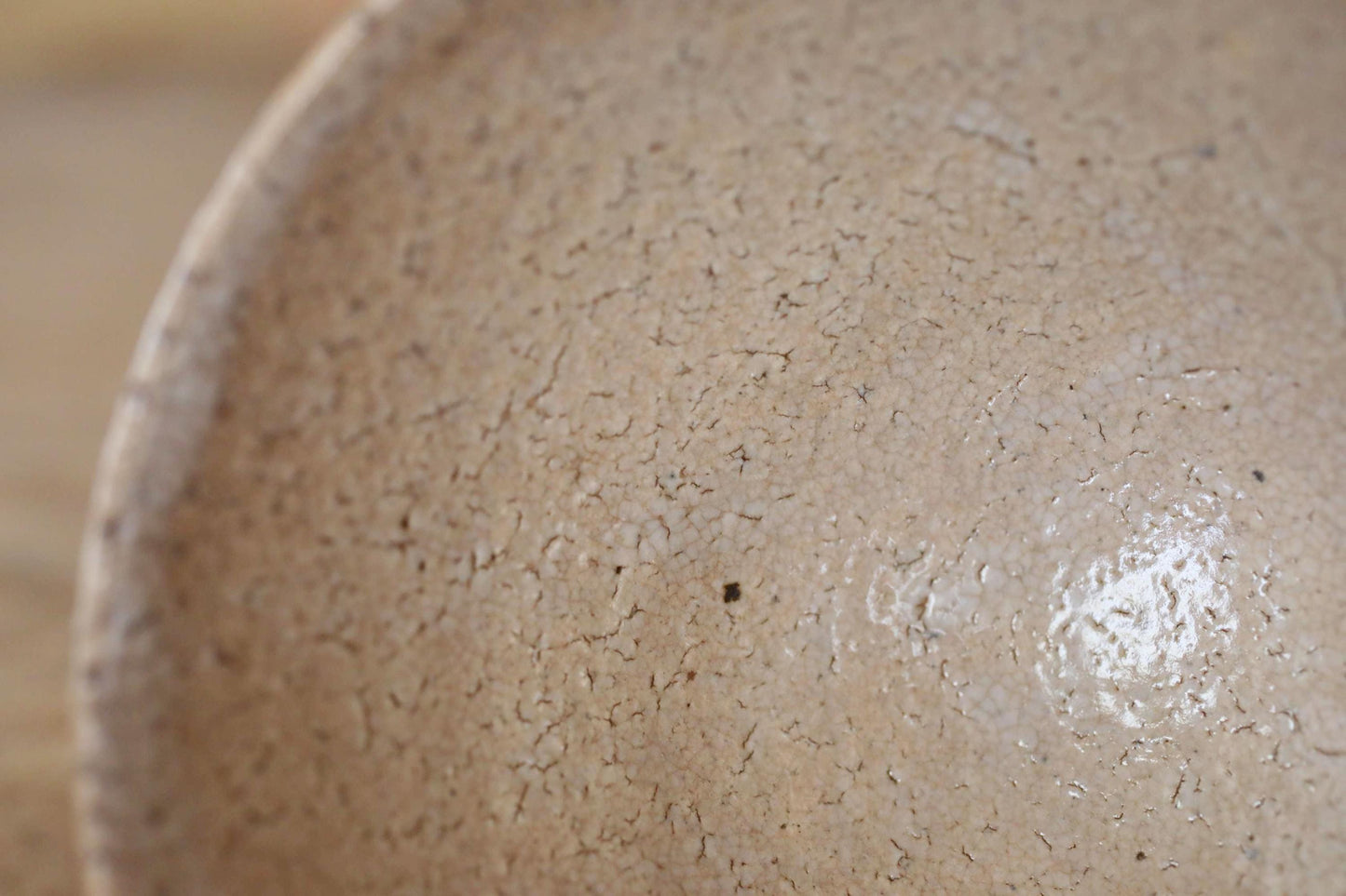 A close-up image of a textured, light brown ceramic bowl or dish.