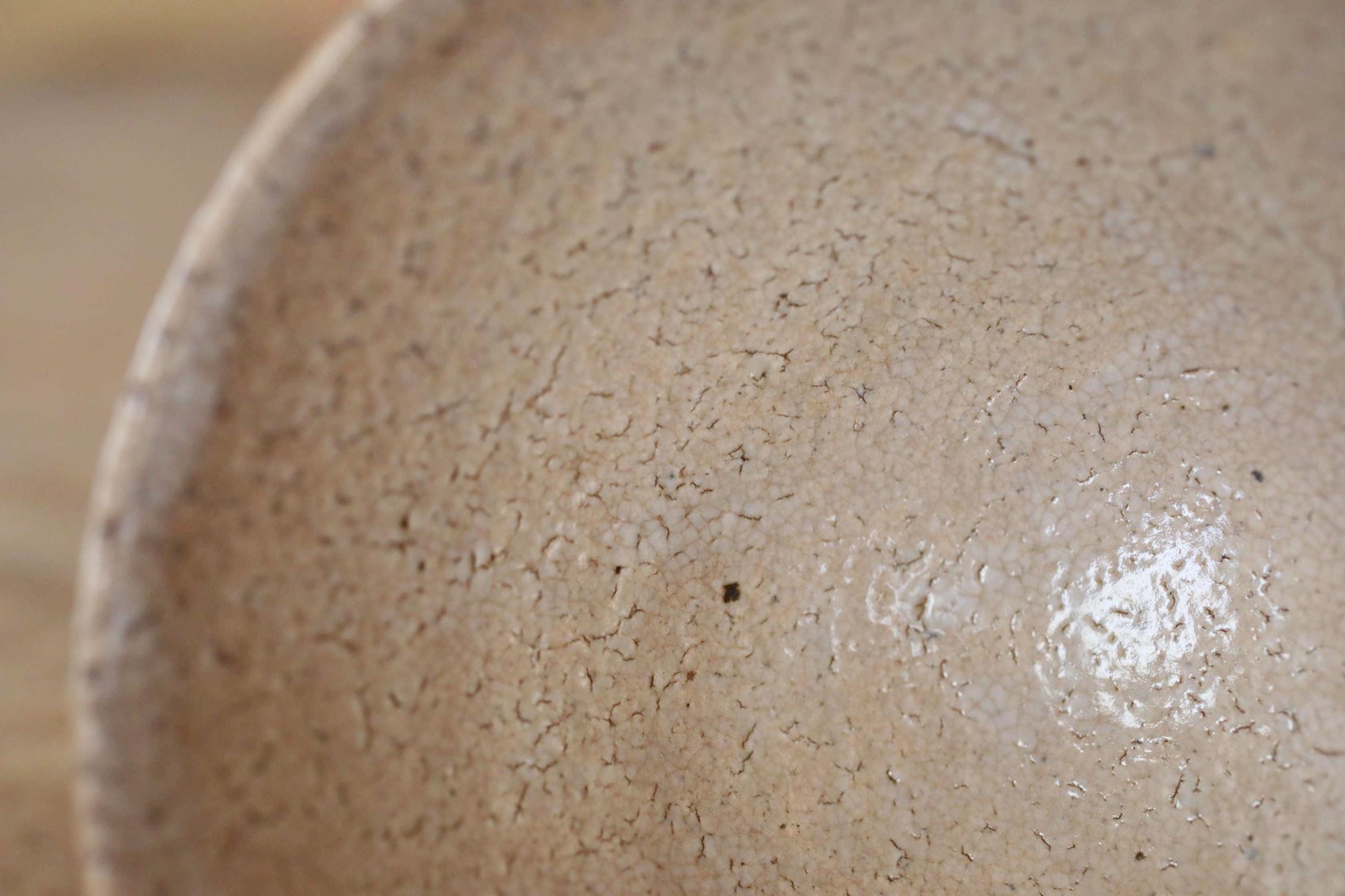 A close-up image of a textured, light brown ceramic bowl or dish.