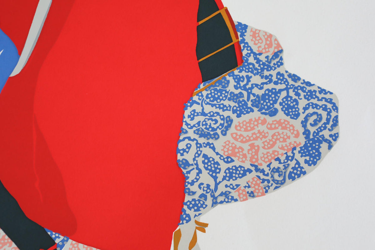 The image is a close-up of a red fabric with a blue and white floral pattern.