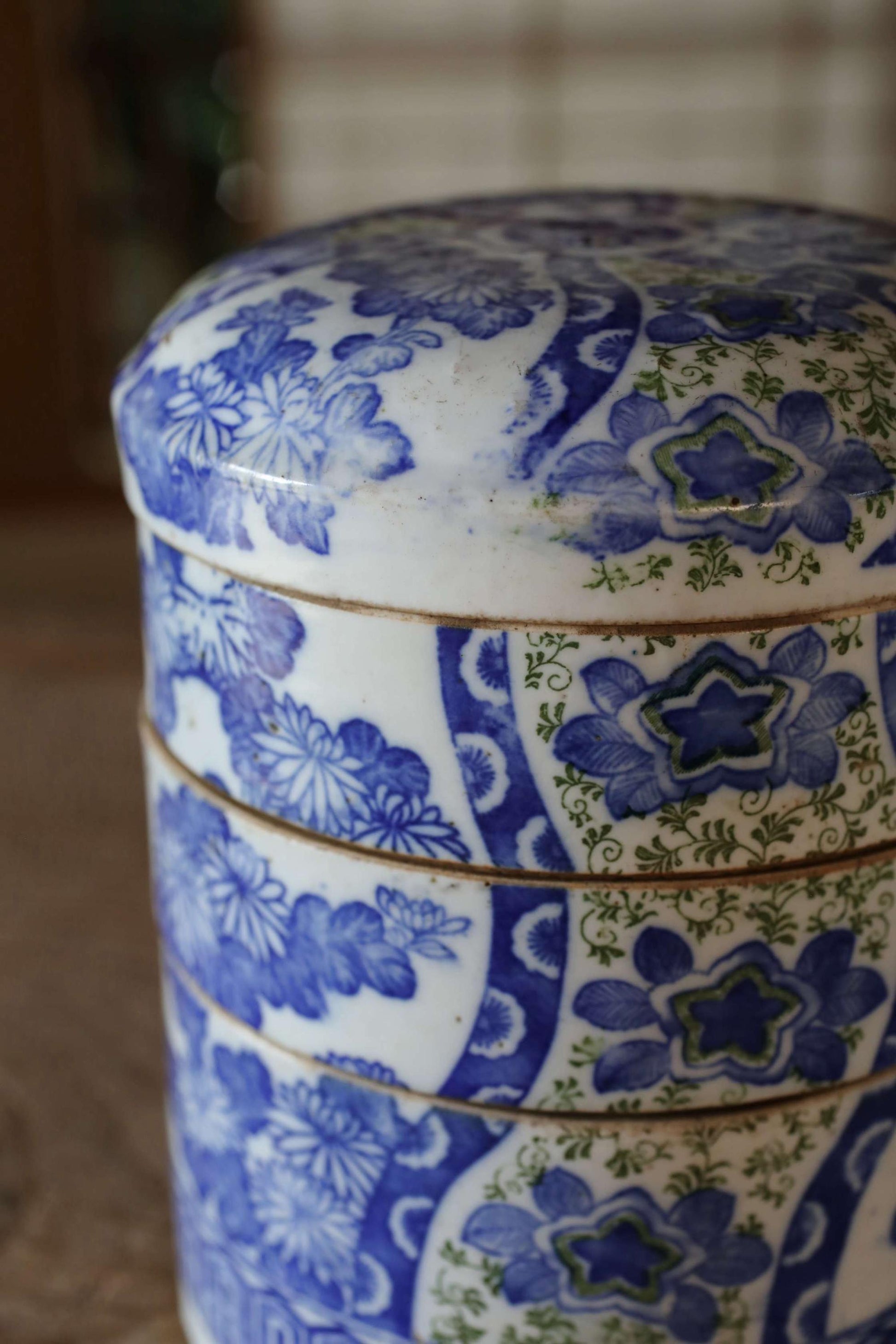 A close-up image of a decorative blue and white ceramic container with intricate floral patterns.