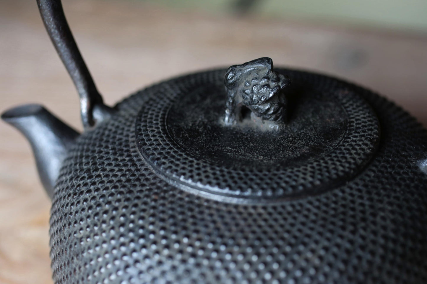 A close-up image of a black metal teapot with a decorative finial on top.