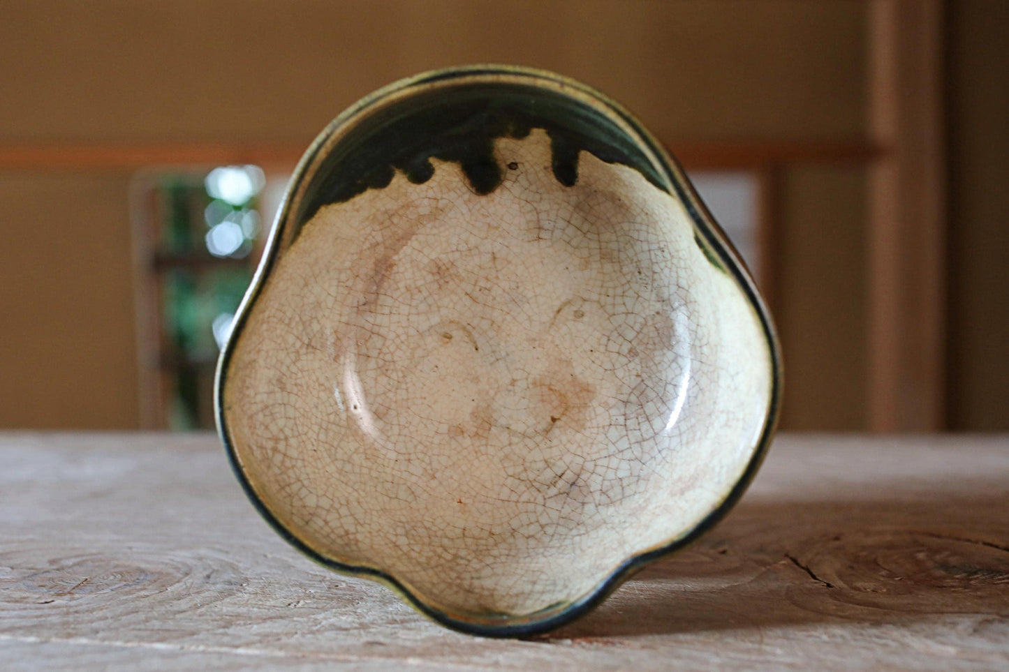 A ceramic bowl with a unique design sits on a wooden surface.