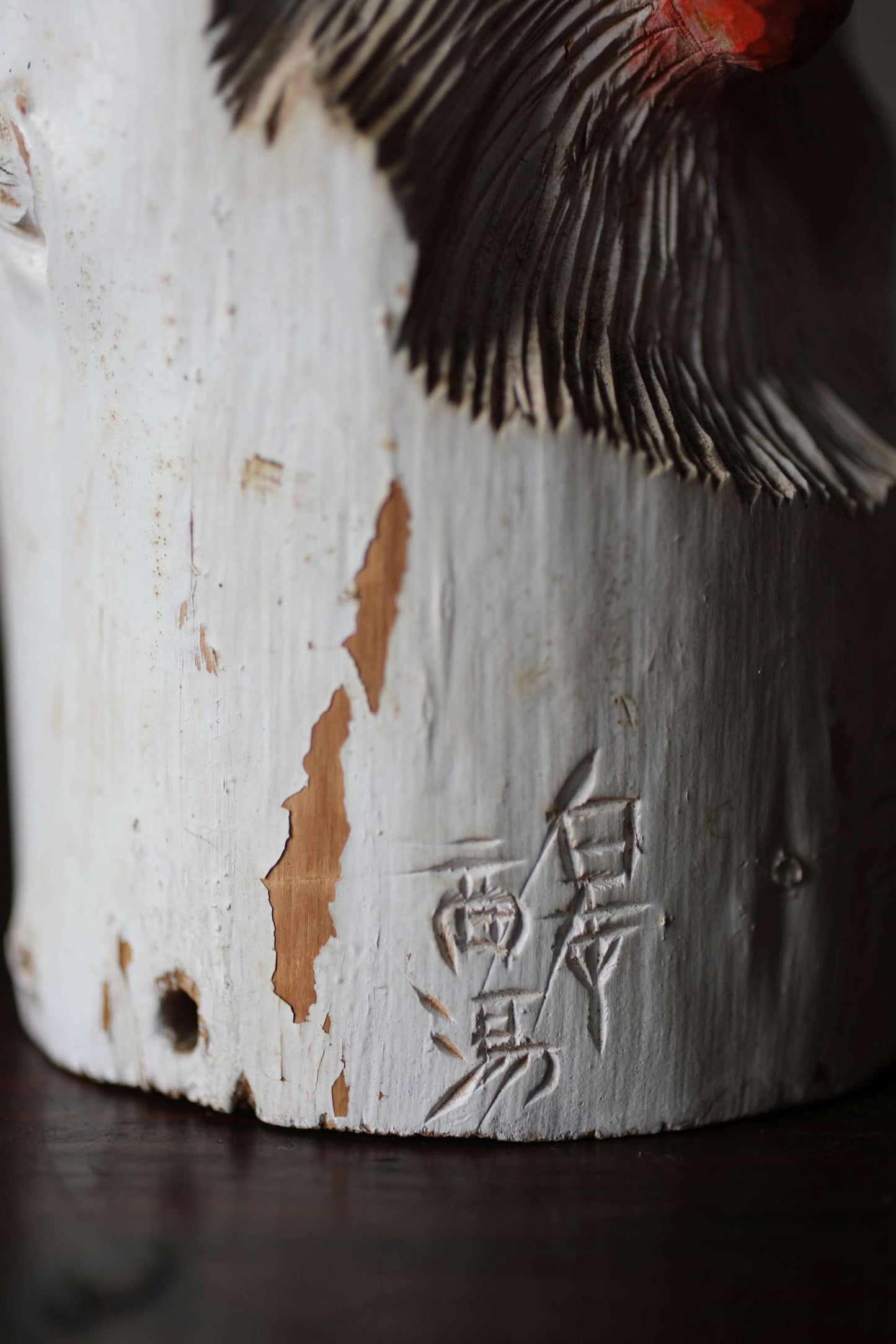 a close-up view of a white, textured surface with a carved design and some text or symbols in a foreign language.