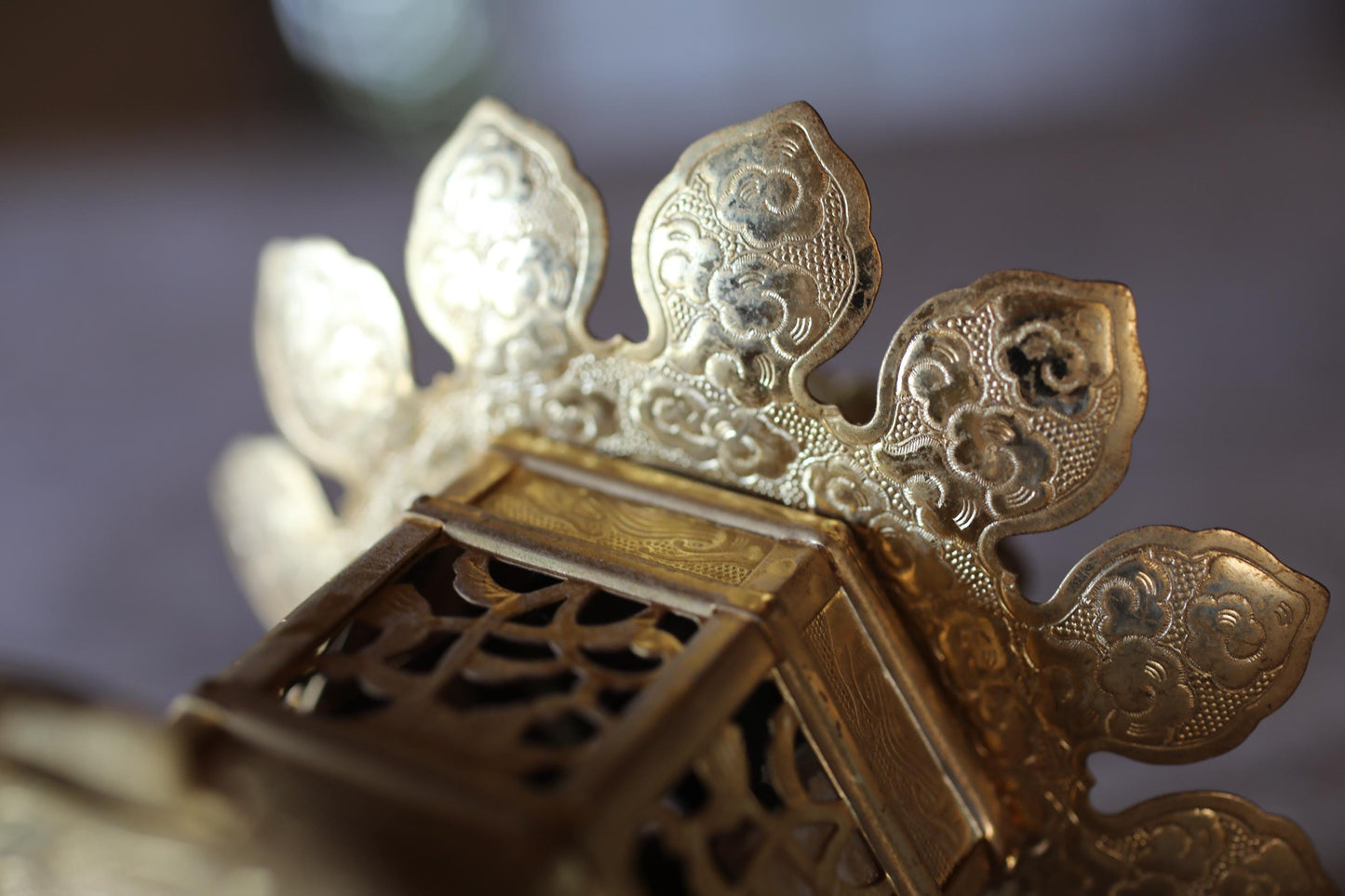 A close-up view of an ornate, golden metal object with intricate, decorative patterns.