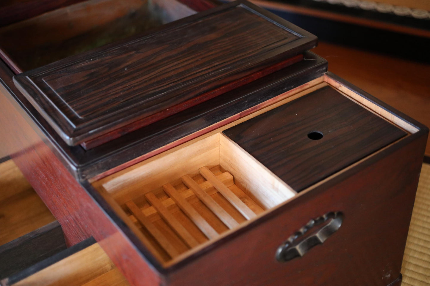a wooden box with a lid and a wooden compartment inside, sitting on a wooden surface.