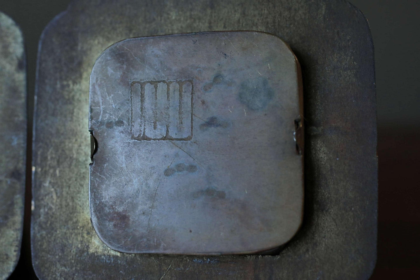 a close-up view of a metal object with a square-shaped design on it.