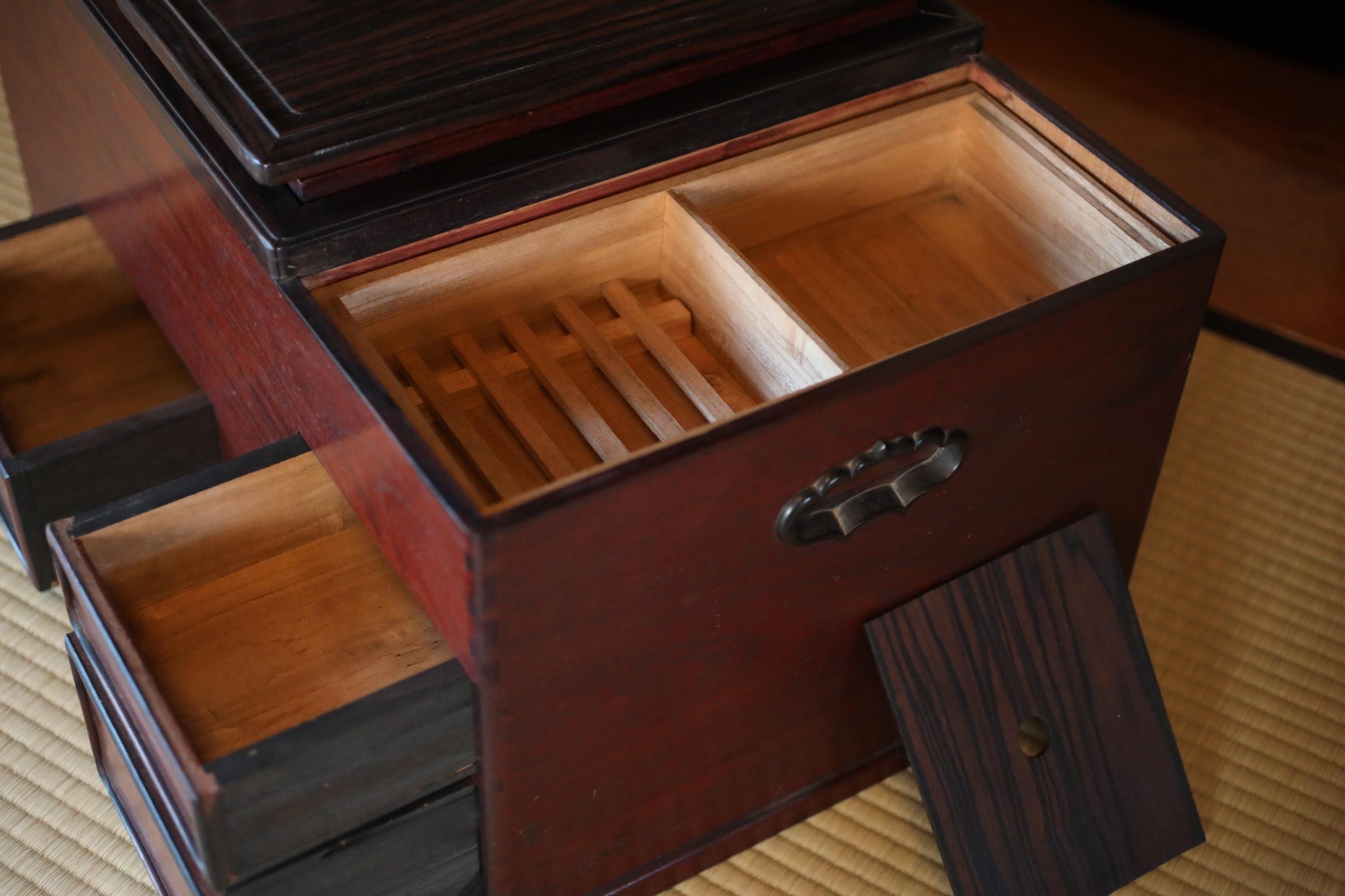 a wooden box with a handle, sitting on a wooden surface.