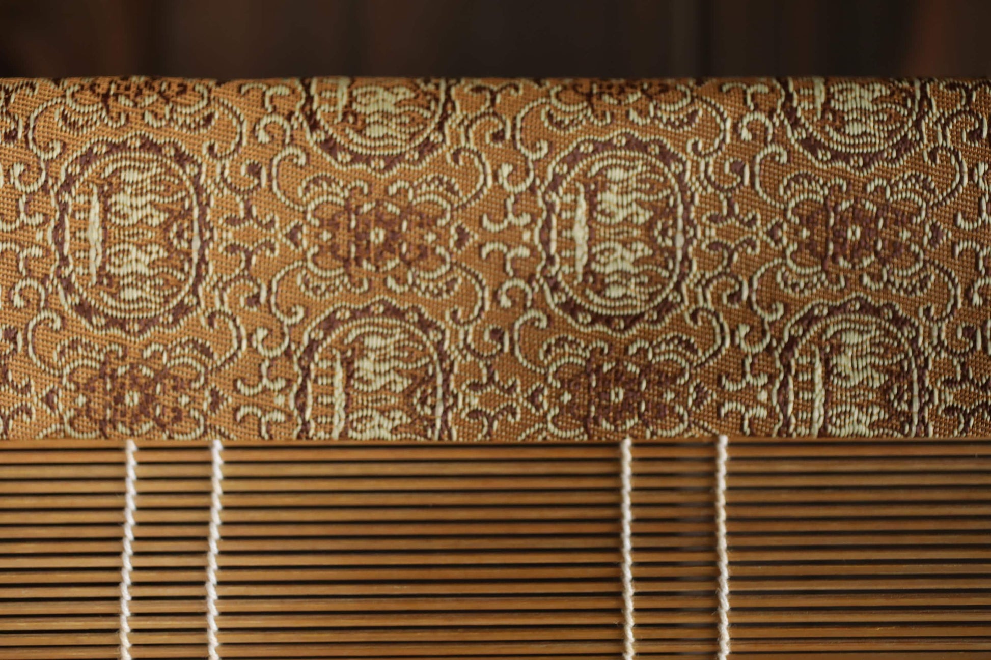 a close-up view of a wooden blind with a decorative pattern on the top half.