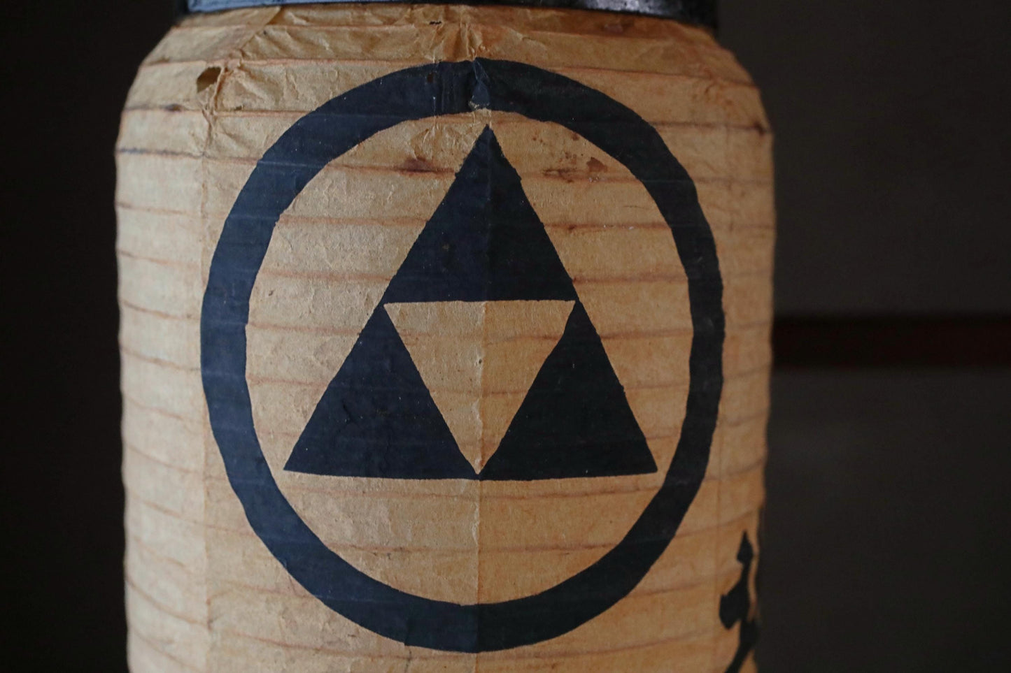 A close-up image of a paper lantern with a black triangle symbol on it.