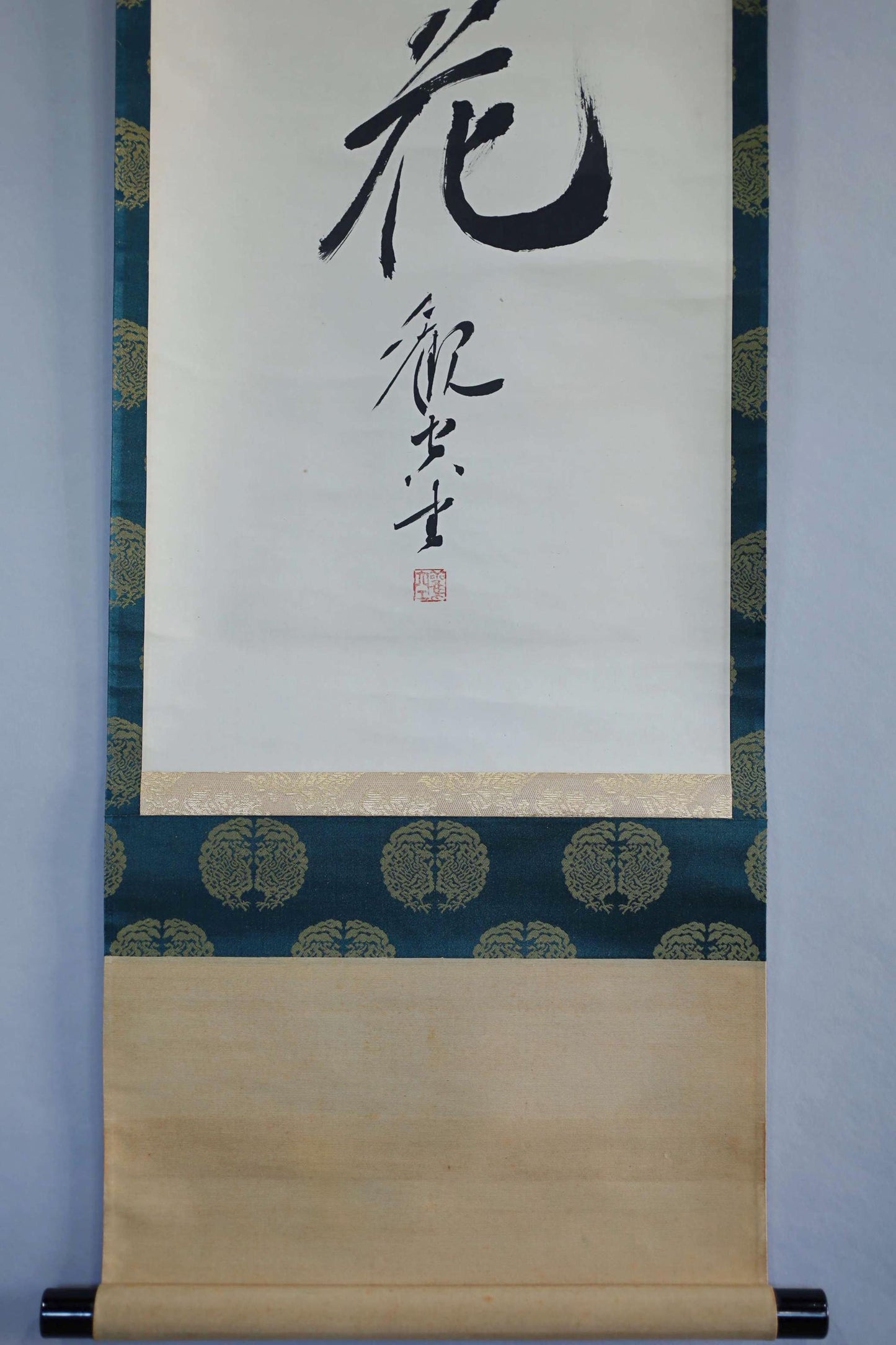 a traditional Japanese scroll with a calligraphic design and a red stamp.