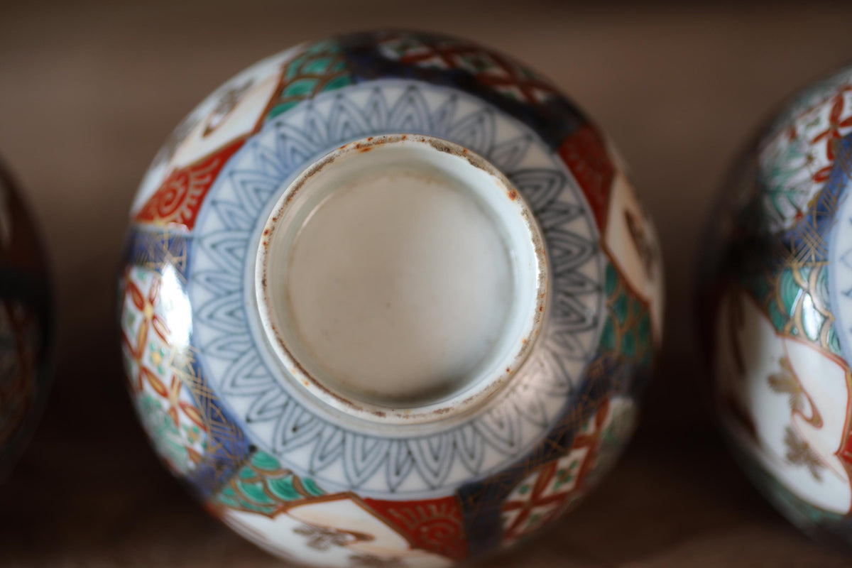 A close-up view of a decorative ceramic vase with intricate patterns and designs in various colors, including blue, red, and white.