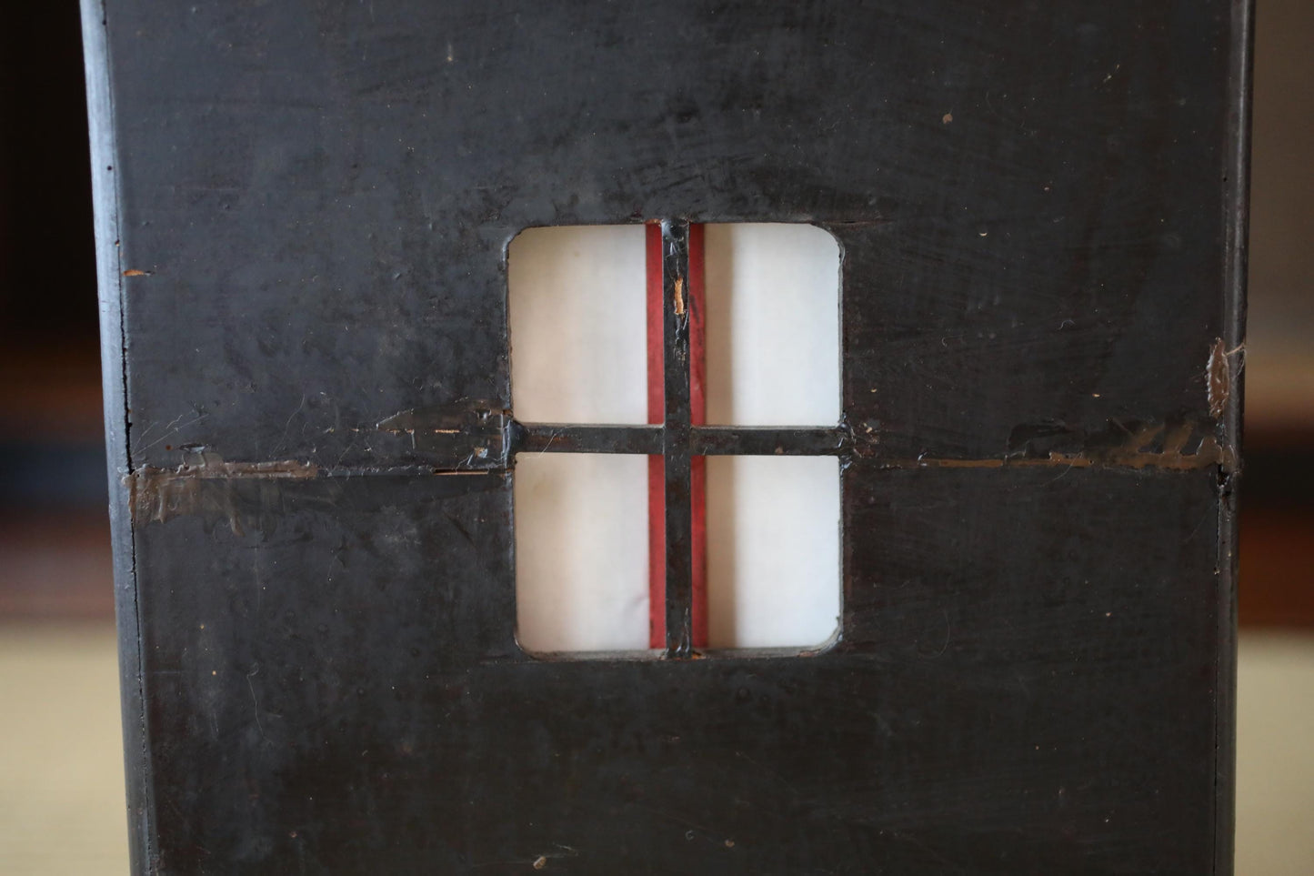 a close-up view of a dark, textured surface with a small, rectangular cutout in the center.