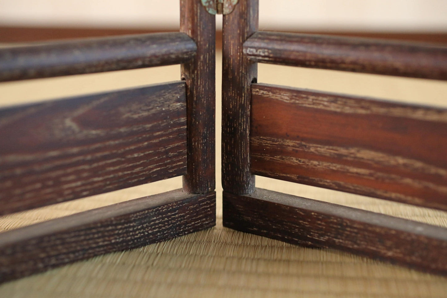 a close-up view of a wooden structure, possibly a piece of furniture or a decorative element, with a textured, weathered appearance.