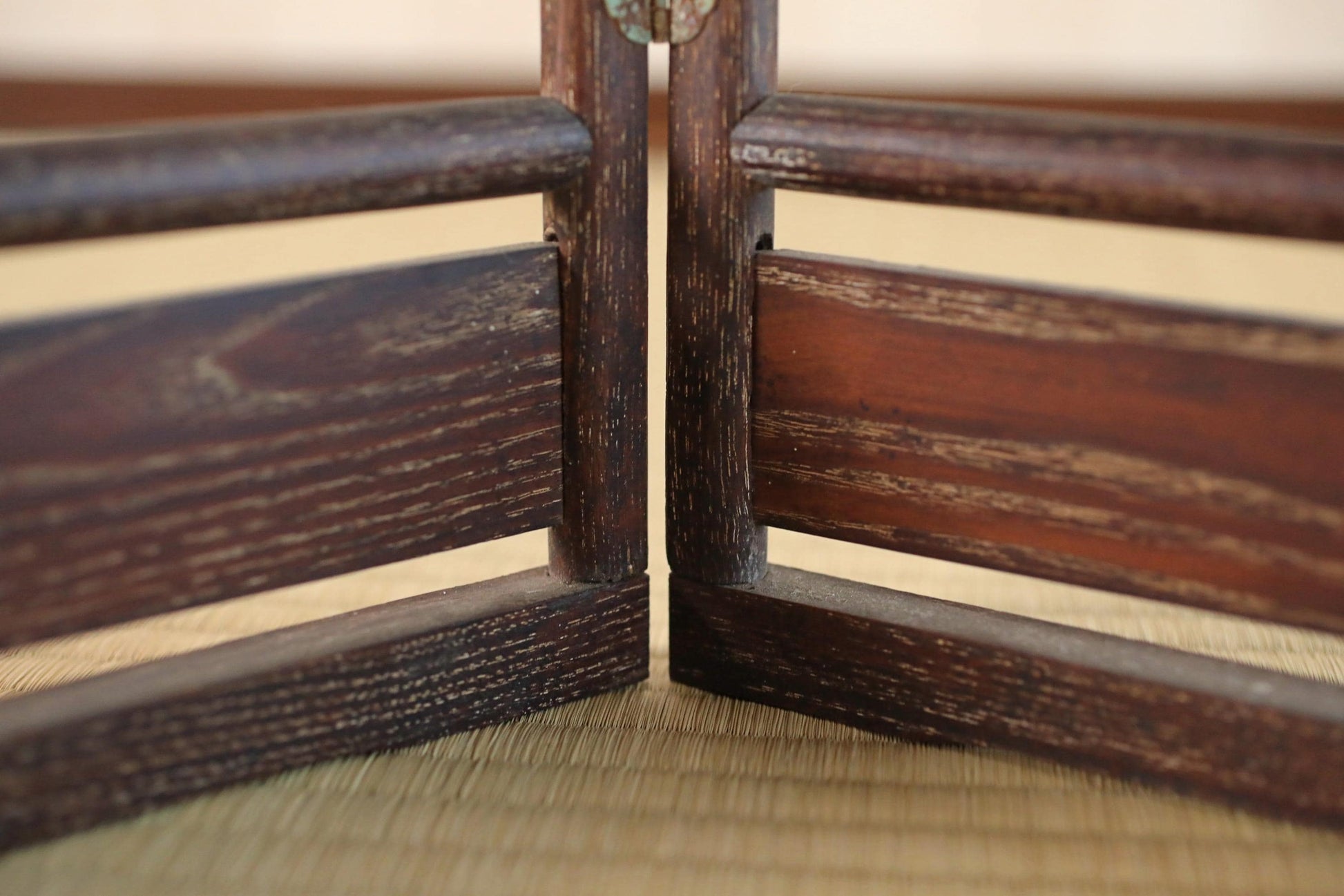 a close-up view of a wooden structure, possibly a piece of furniture or a decorative element, with a textured, weathered appearance.