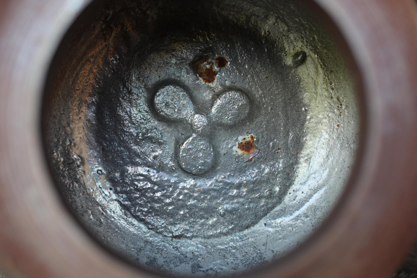 a close-up view of a metal surface with a distinctive symbol or logo carved into it.
