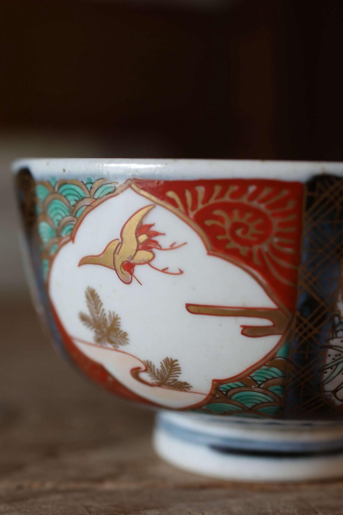 A close-up image of a decorative ceramic bowl with intricate patterns and designs, including a bird and floral motifs.