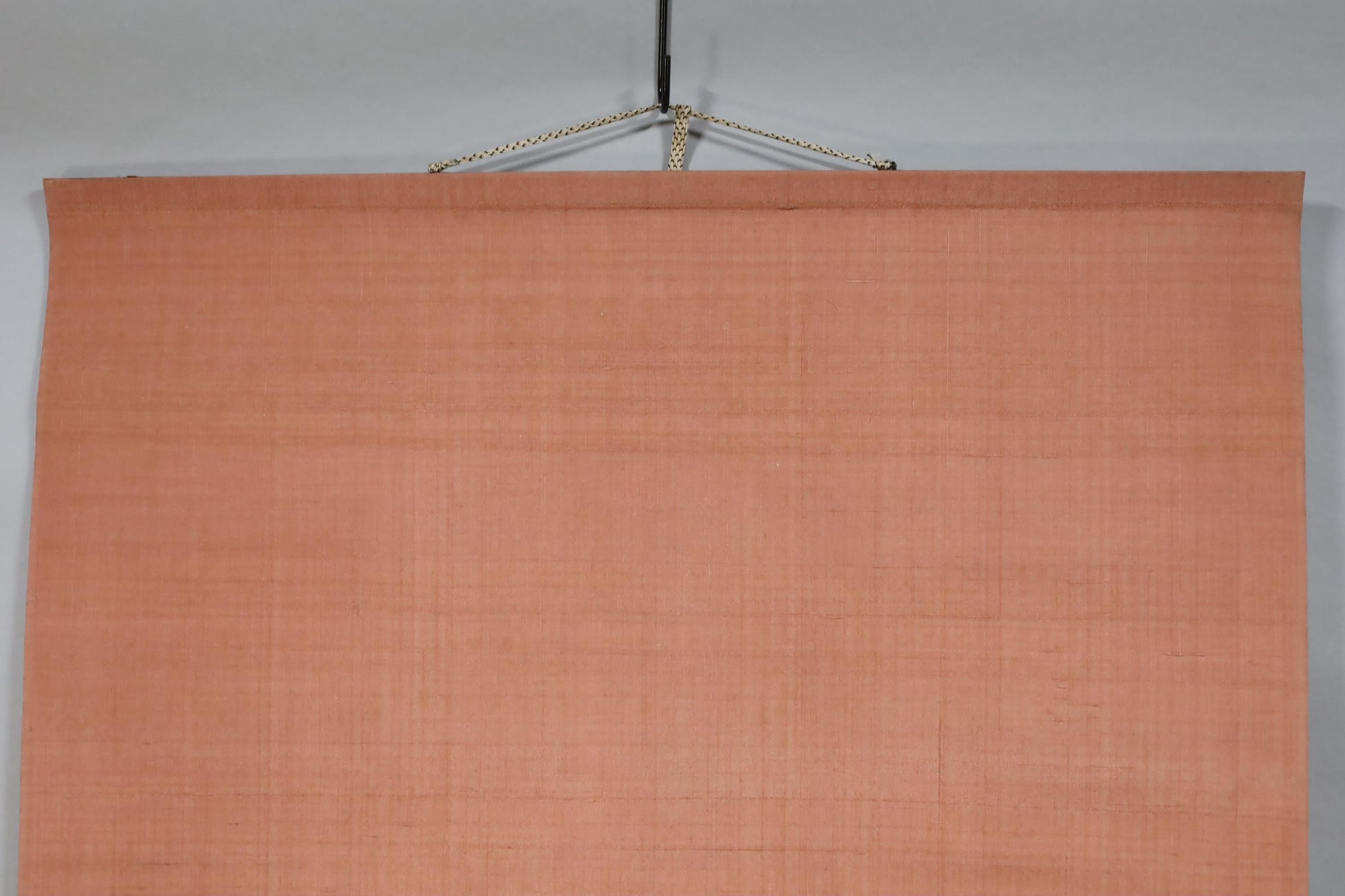 a large, blank canvas hanging from a rope.